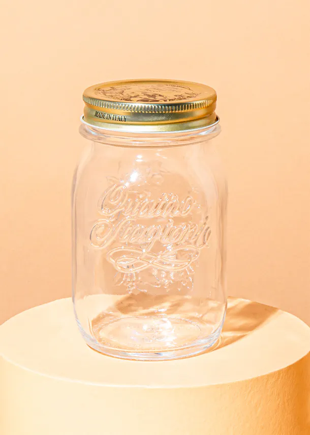 ein Glasgefäß mit einem goldenen Deckel und der Aufschrift " made in italy "