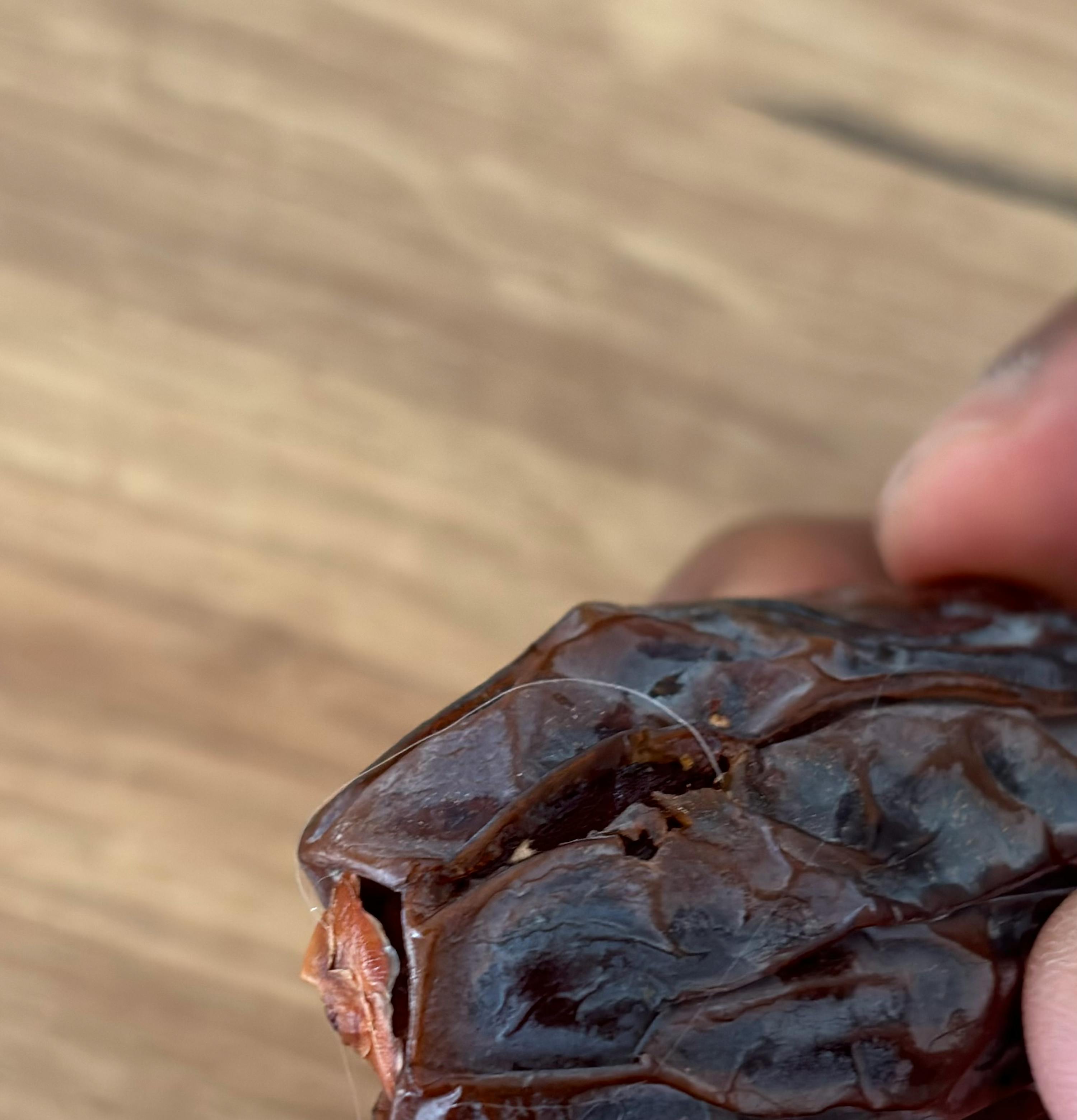 a close up of a person 's hand holding a piece of chocolate
