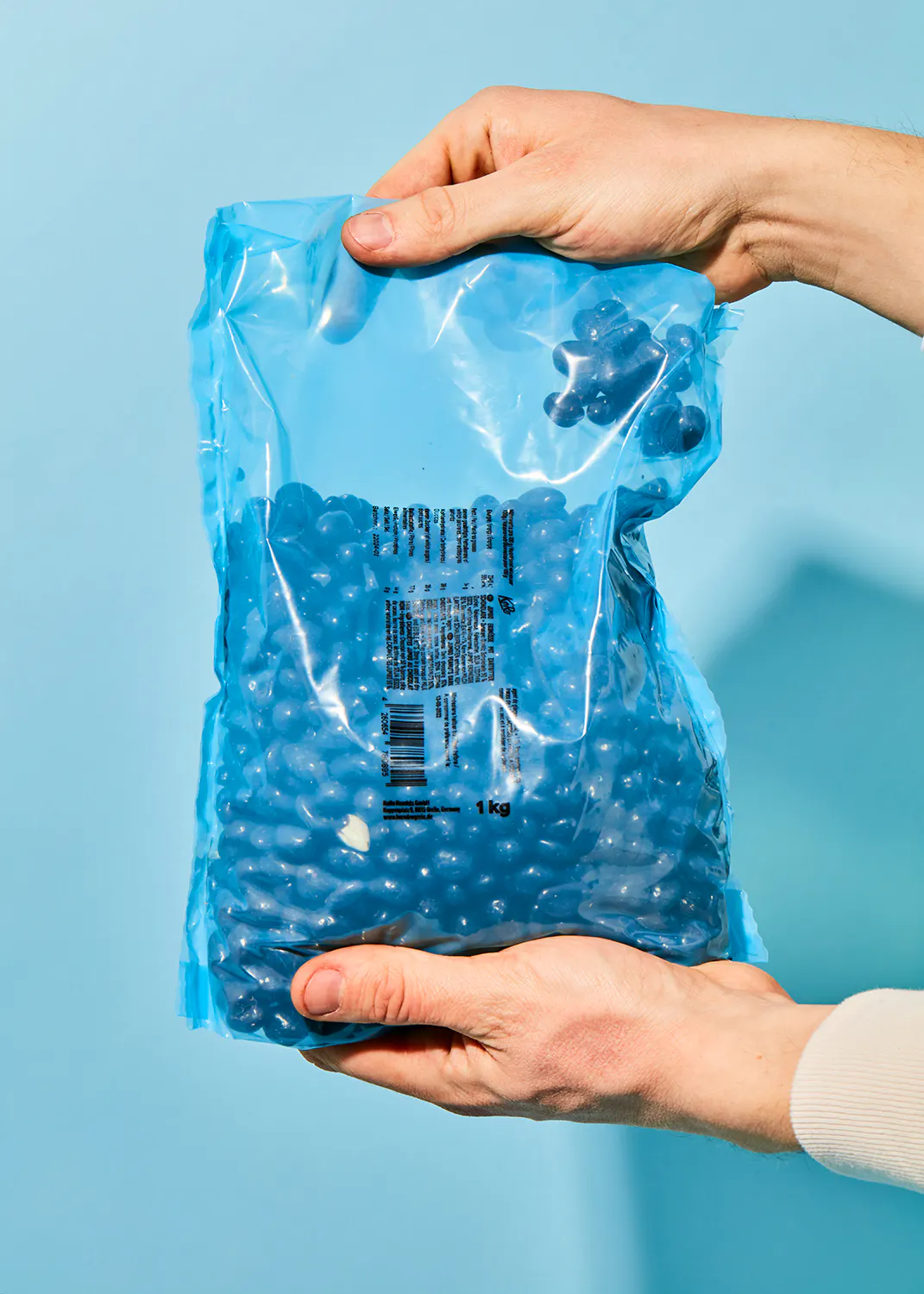 a person is holding a bag of blue beans in their hands