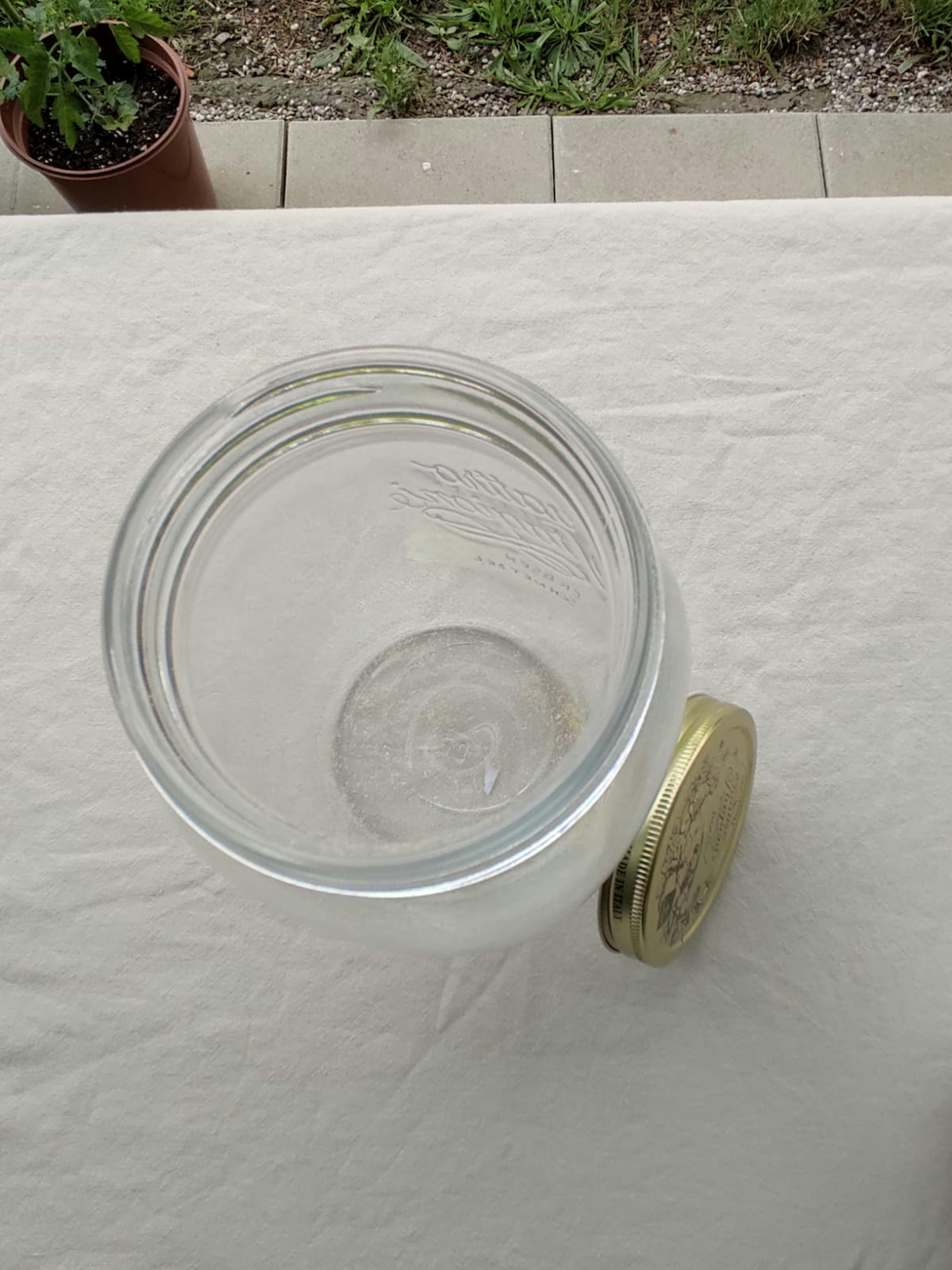 ein Glasgefäß mit einem goldenen Deckel auf einem Tisch