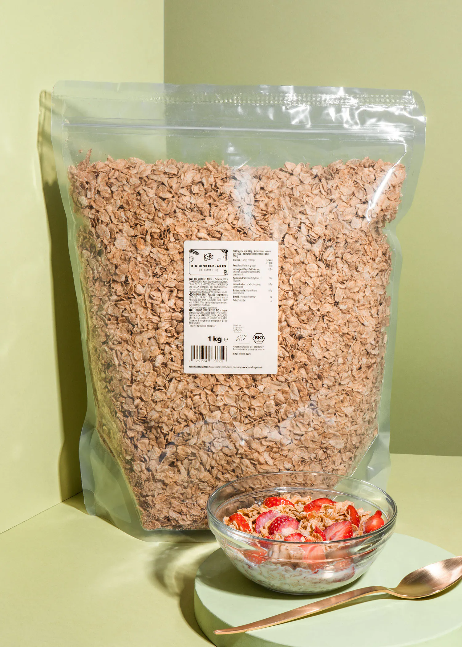 eine Tüte Haferflocken steht neben einer Schüssel Haferflocken mit Erdbeeren