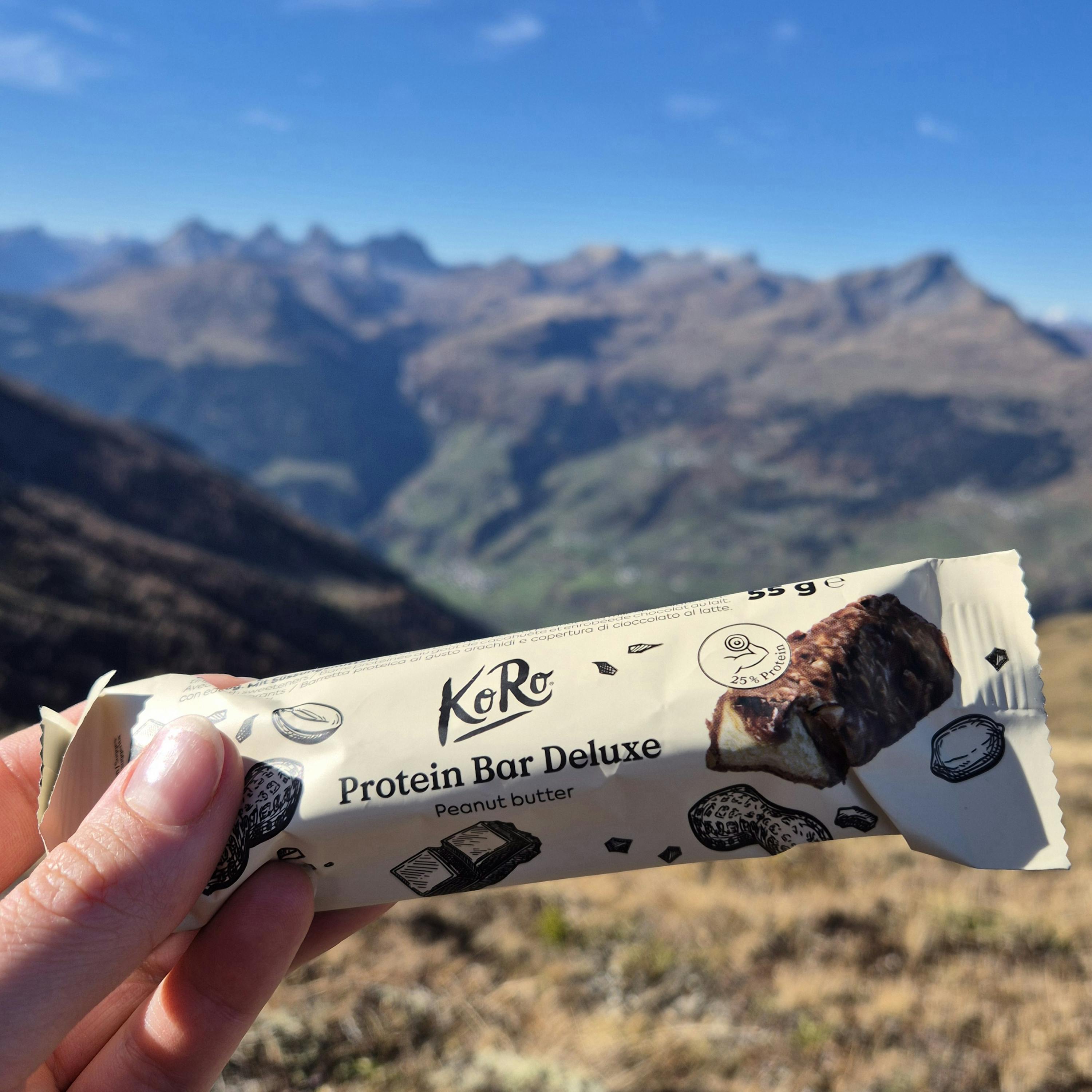 una persona tiene in mano una barretta di proteine con burro di arachidi