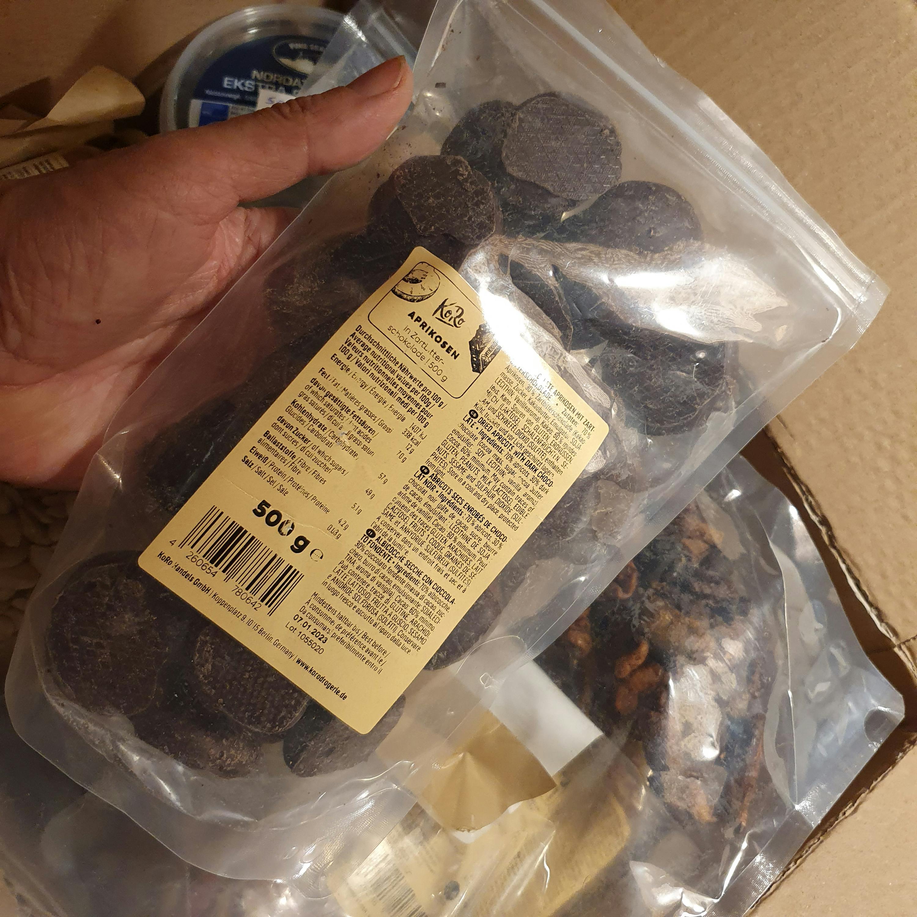 Eine Person hält einen Plastikbeutel mit Schokoladenstücken in der Hand