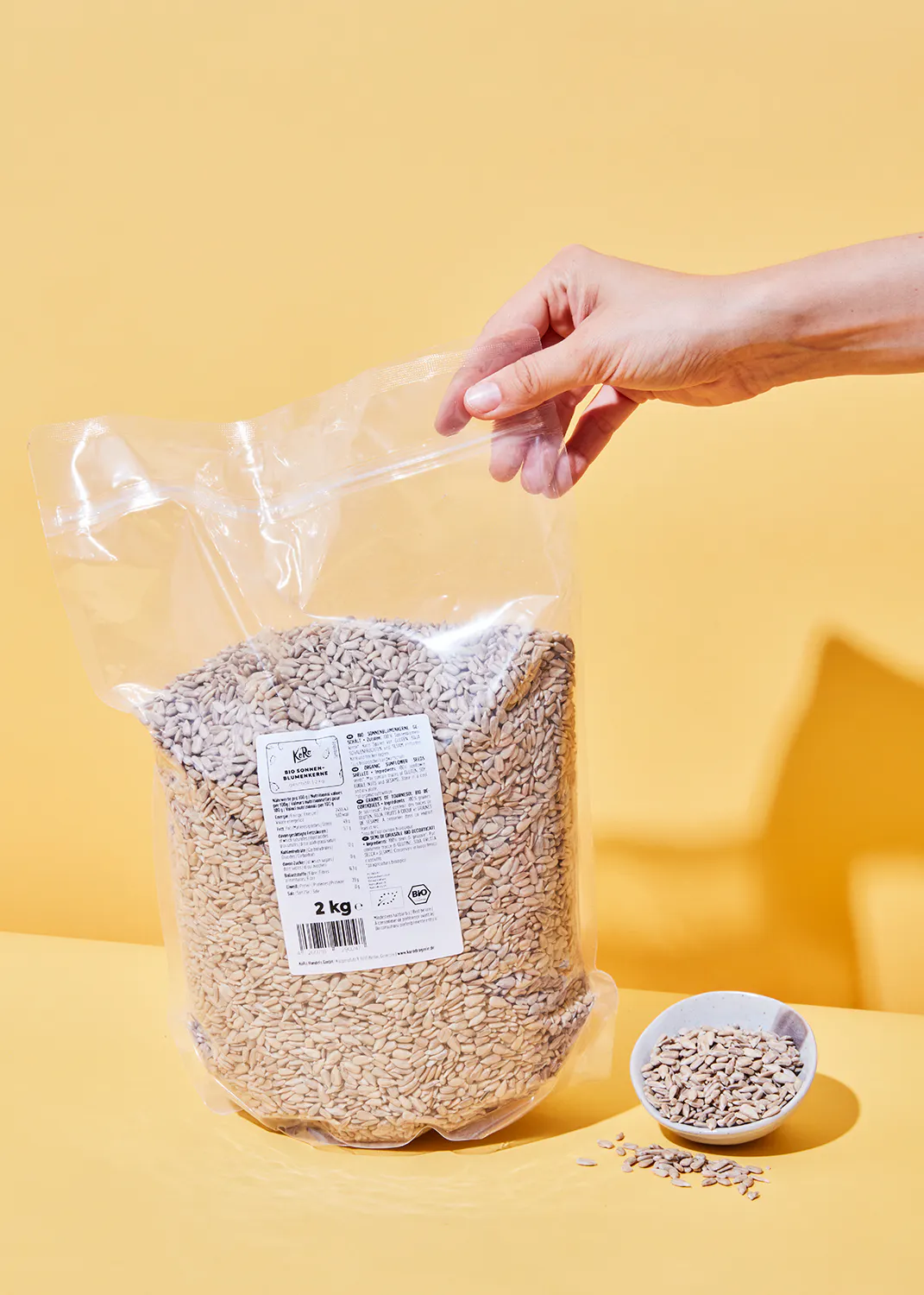une personne tient un sac de graines de tournesol