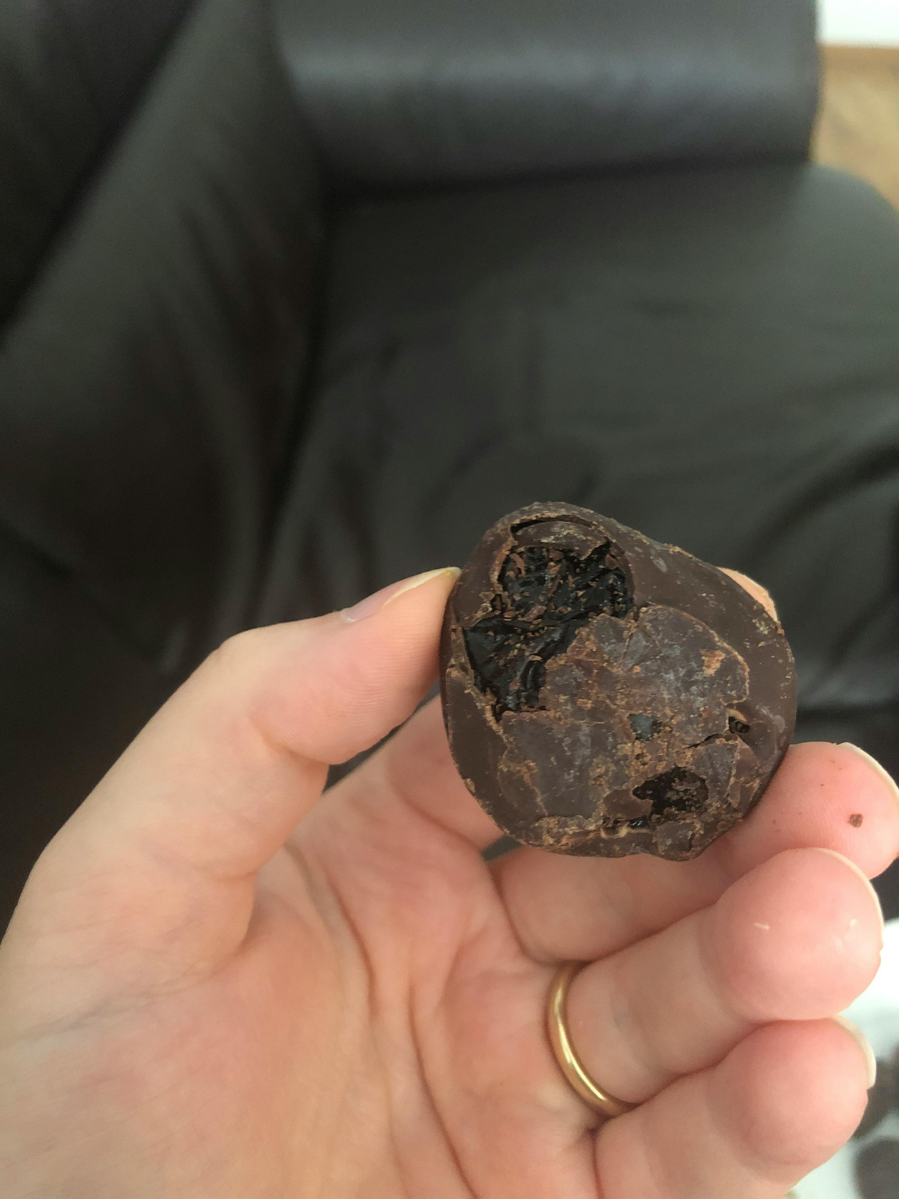 une femme tient un morceau de chocolat dans sa main