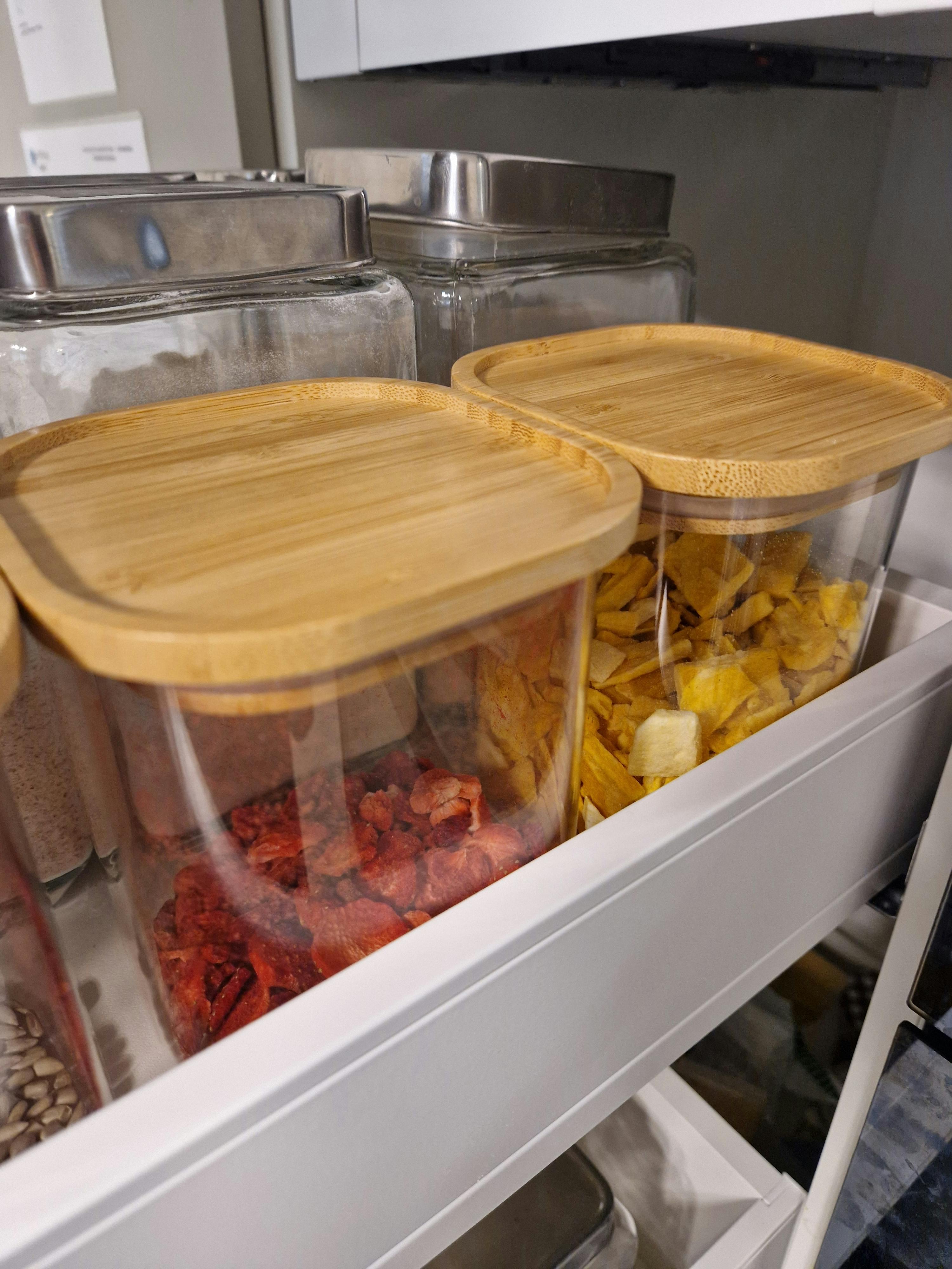 a glass container with a wooden lid is filled with food