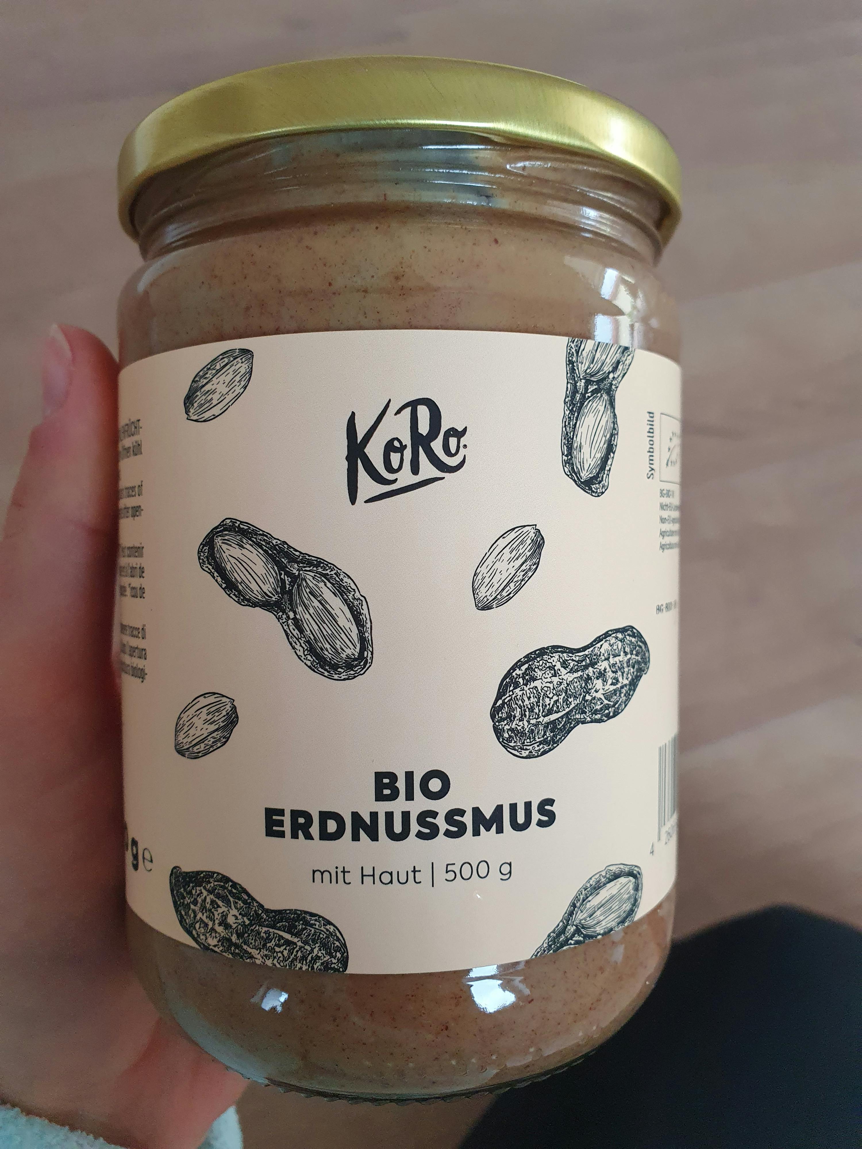 a jar of bio erdnussmus is being held in someone 's hand