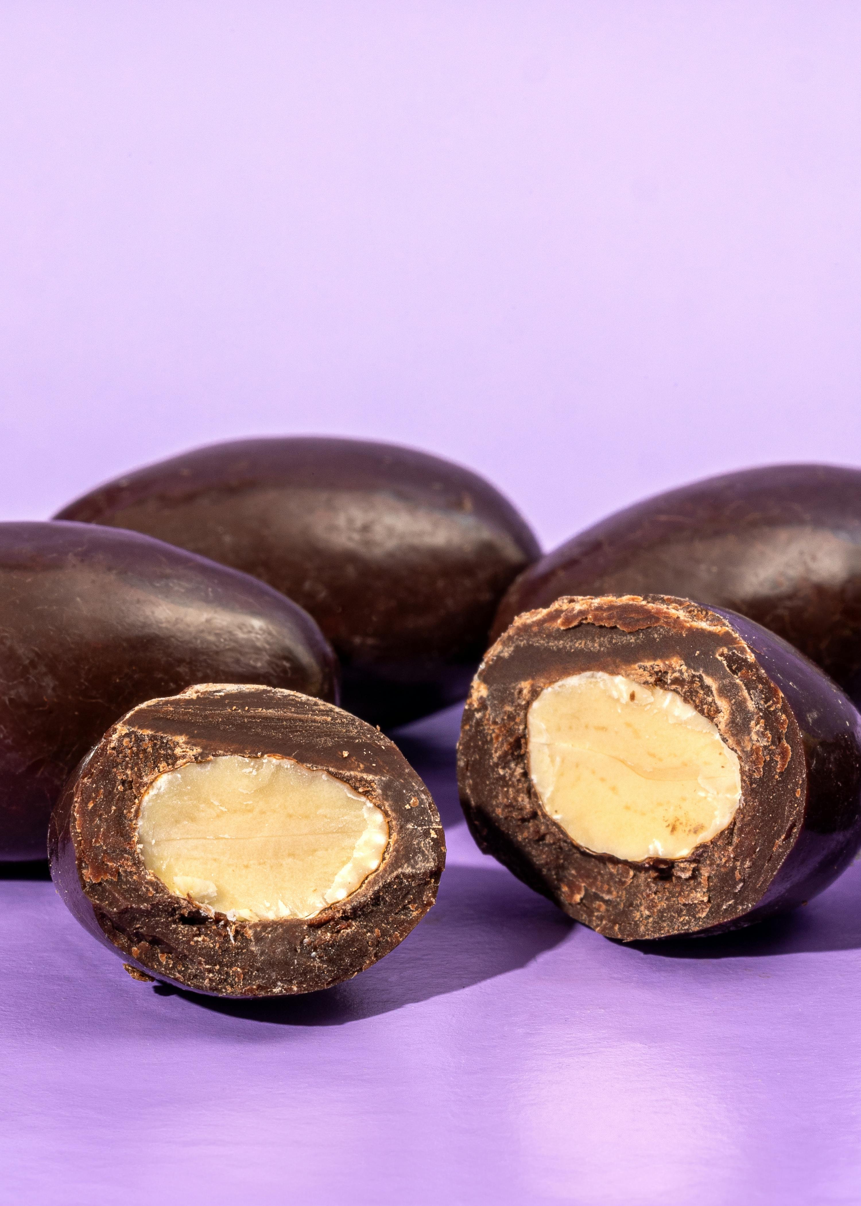 un gruppo di cioccolato e mandorle su un tavolo viola
