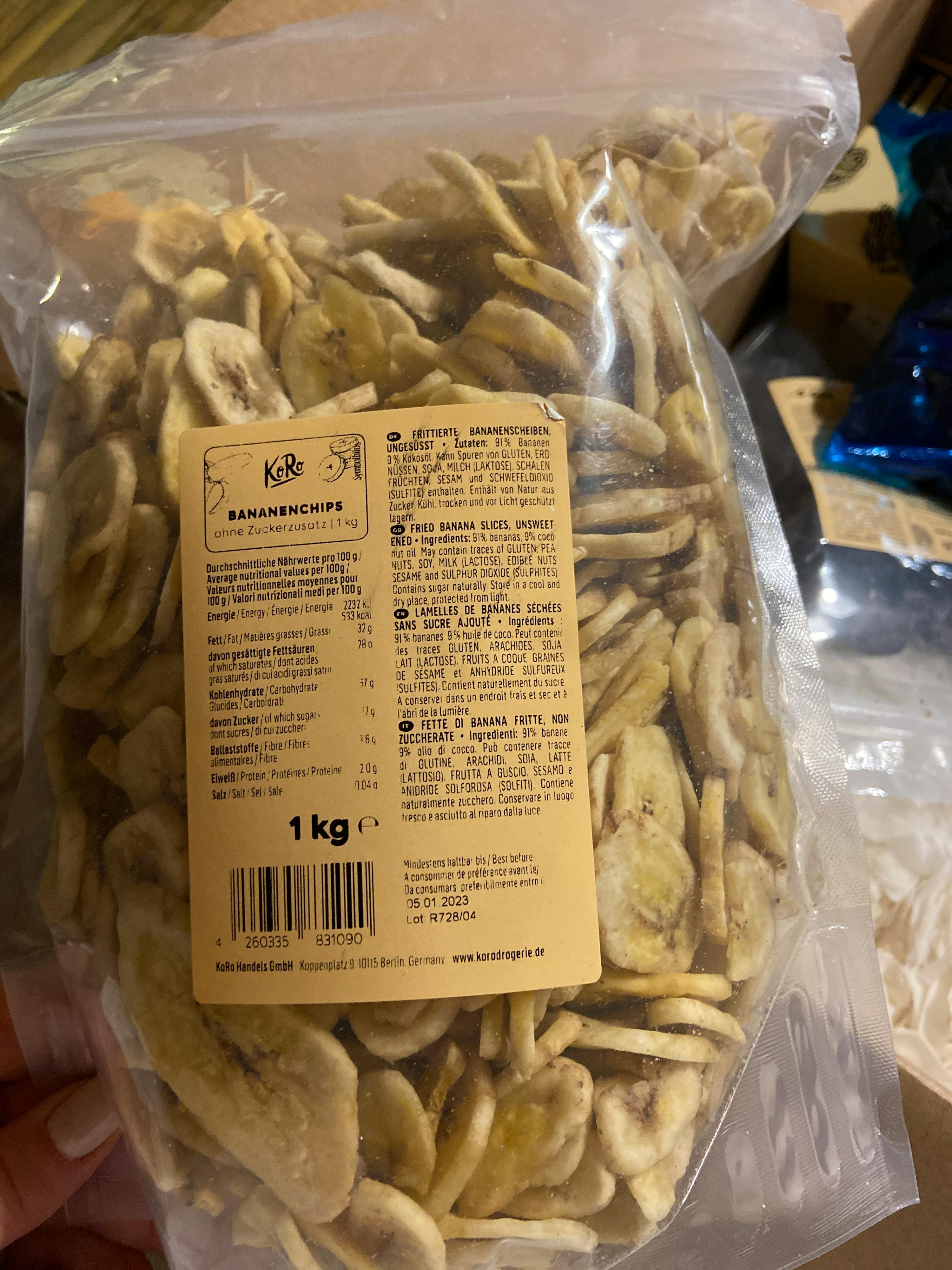 Eine Person hält einen Plastikbeutel mit Bananenchips in der Hand