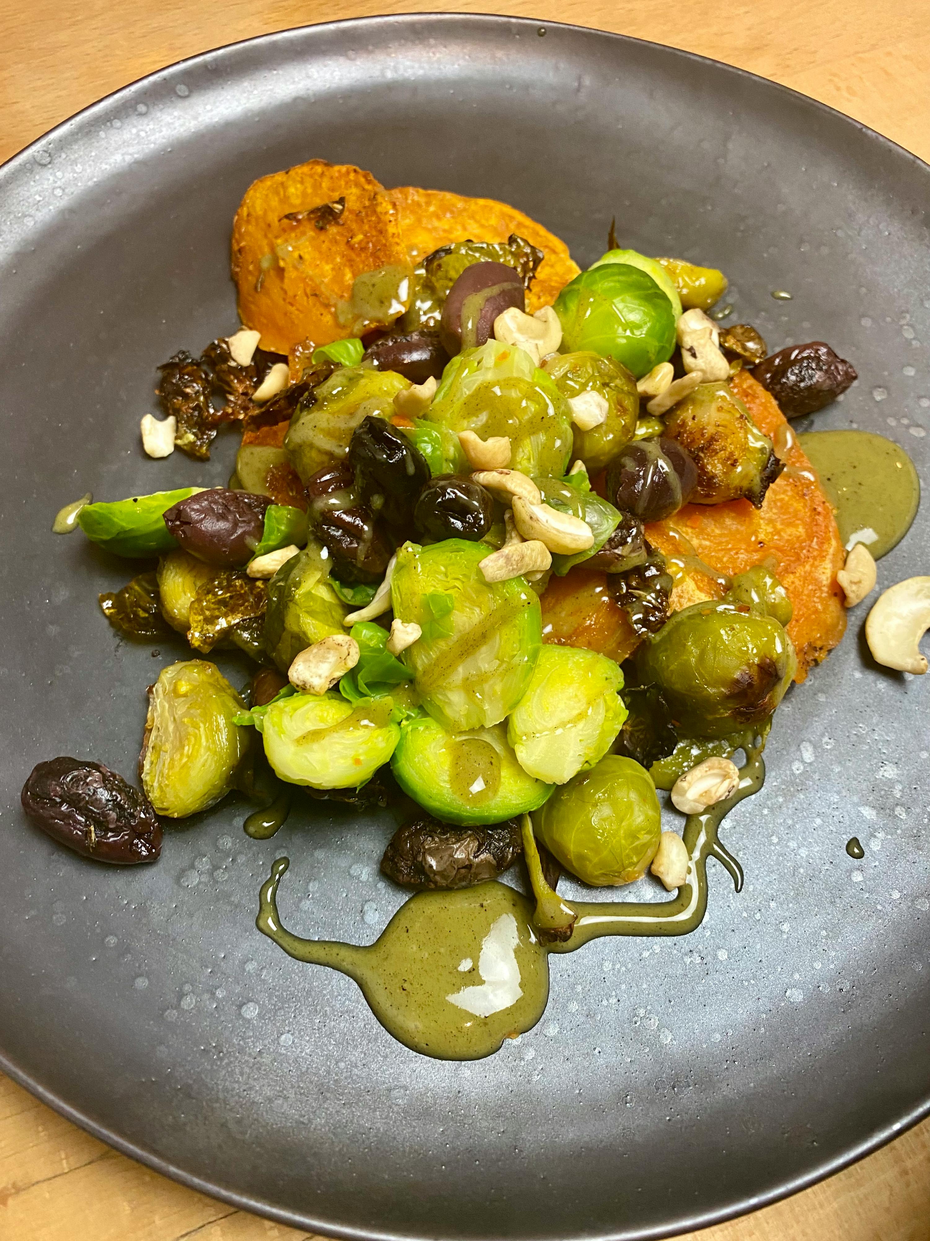 a plate of food with brussels sprouts and nuts on it