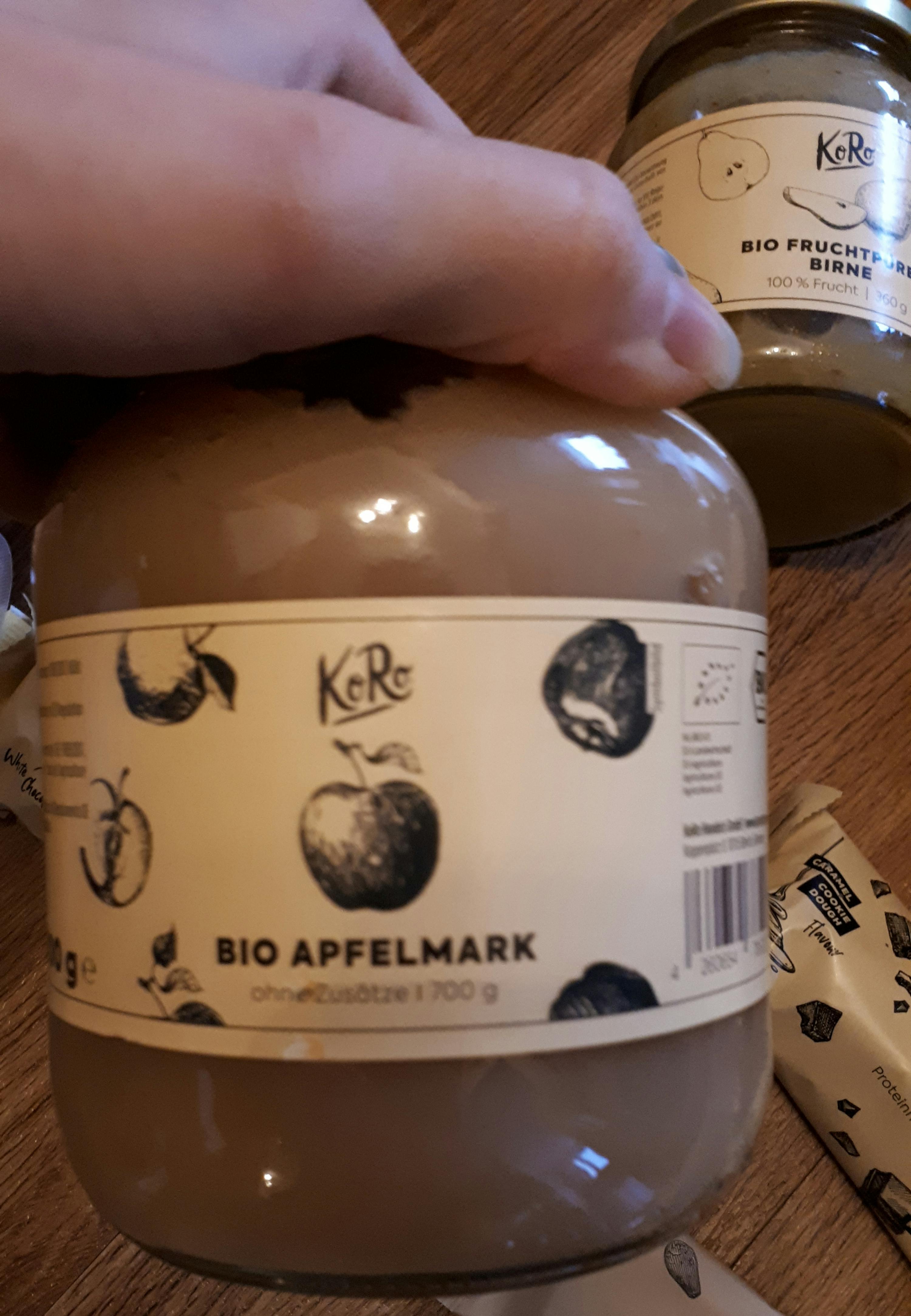 una persona tiene in mano un barattolo di cibo con l' etichetta bio apfelmark