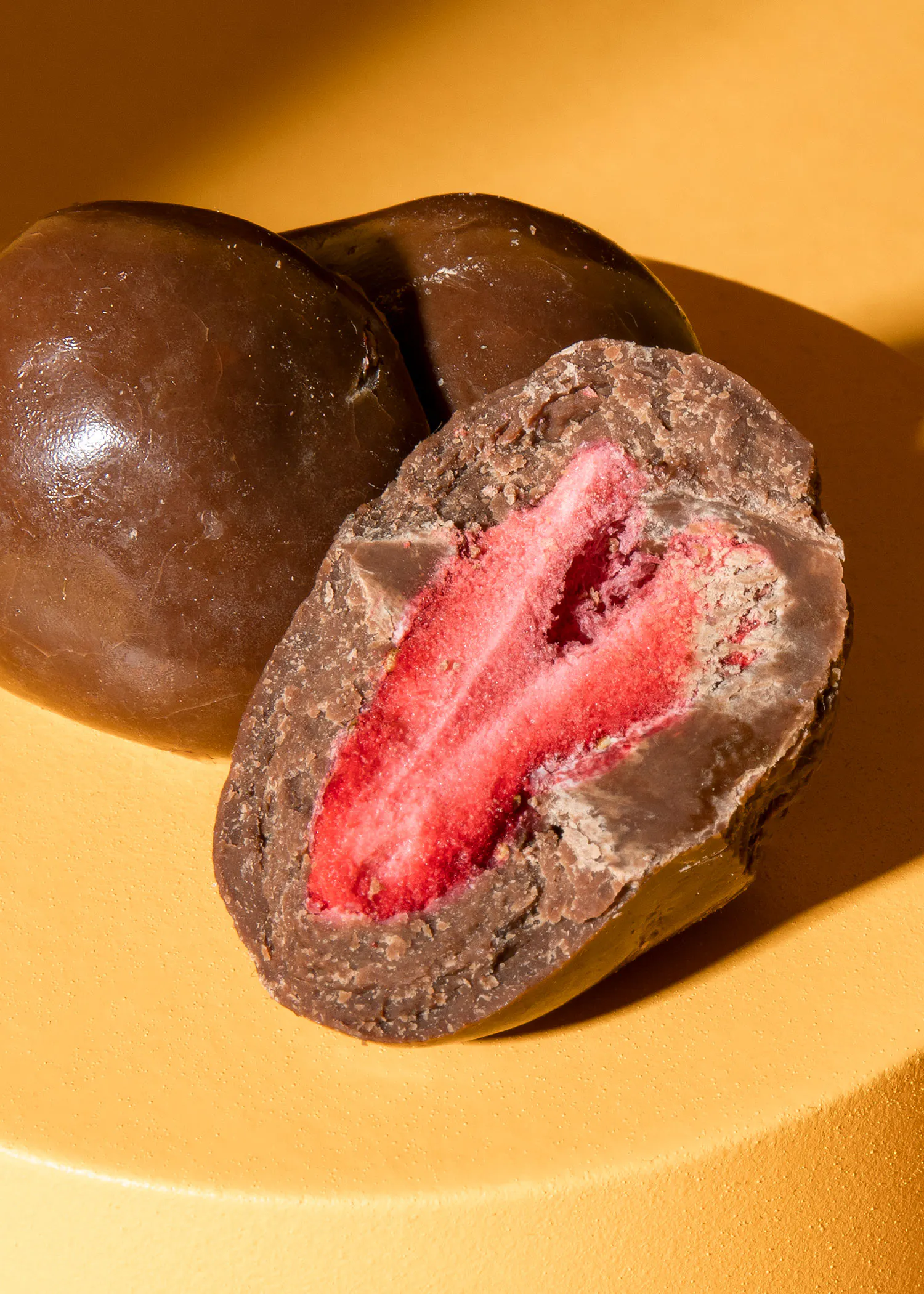 un gros plan d' un chocolat avec une fraise à l' intérieur