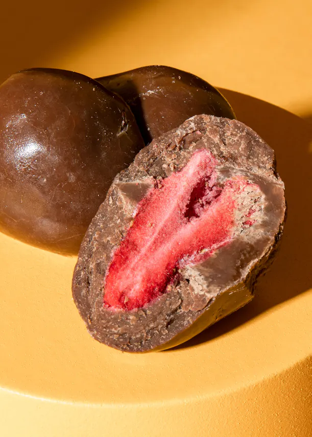 un gros plan d' un chocolat avec une fraise à l' intérieur