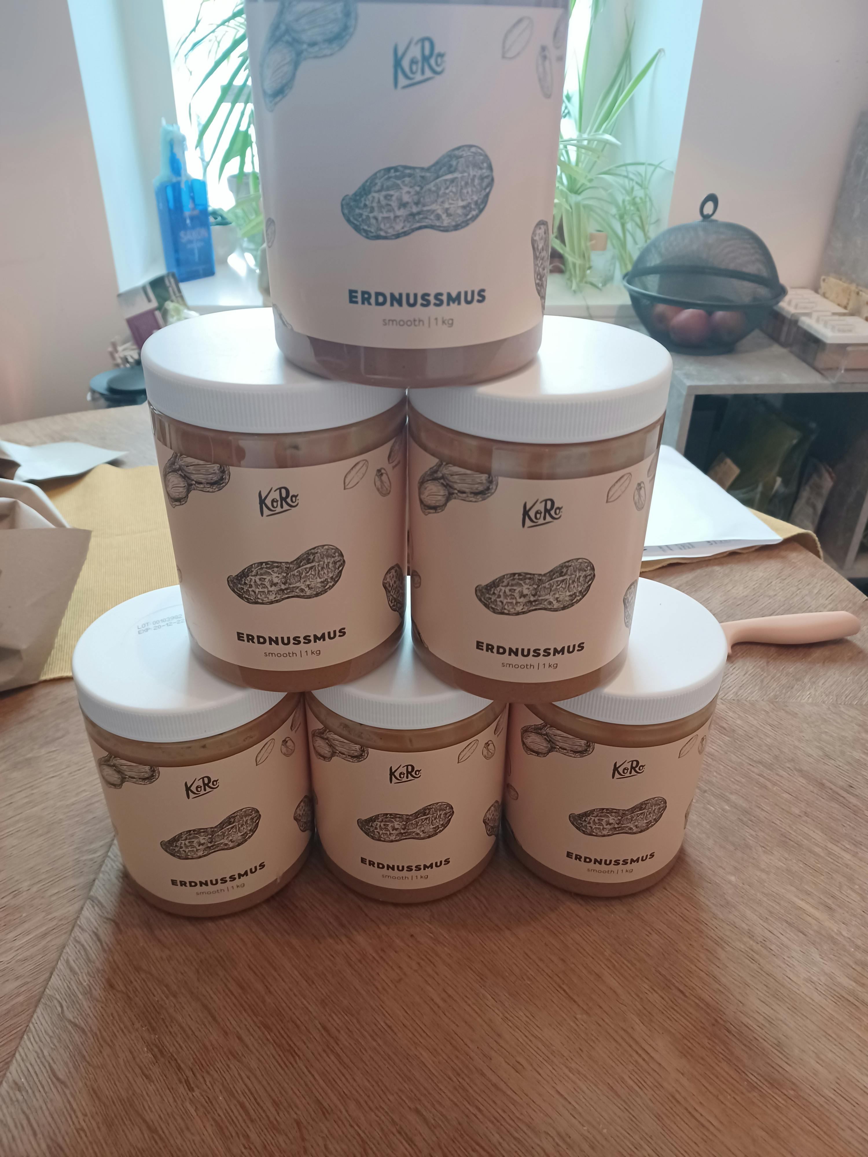 four jars of peanut butter are stacked on top of each other