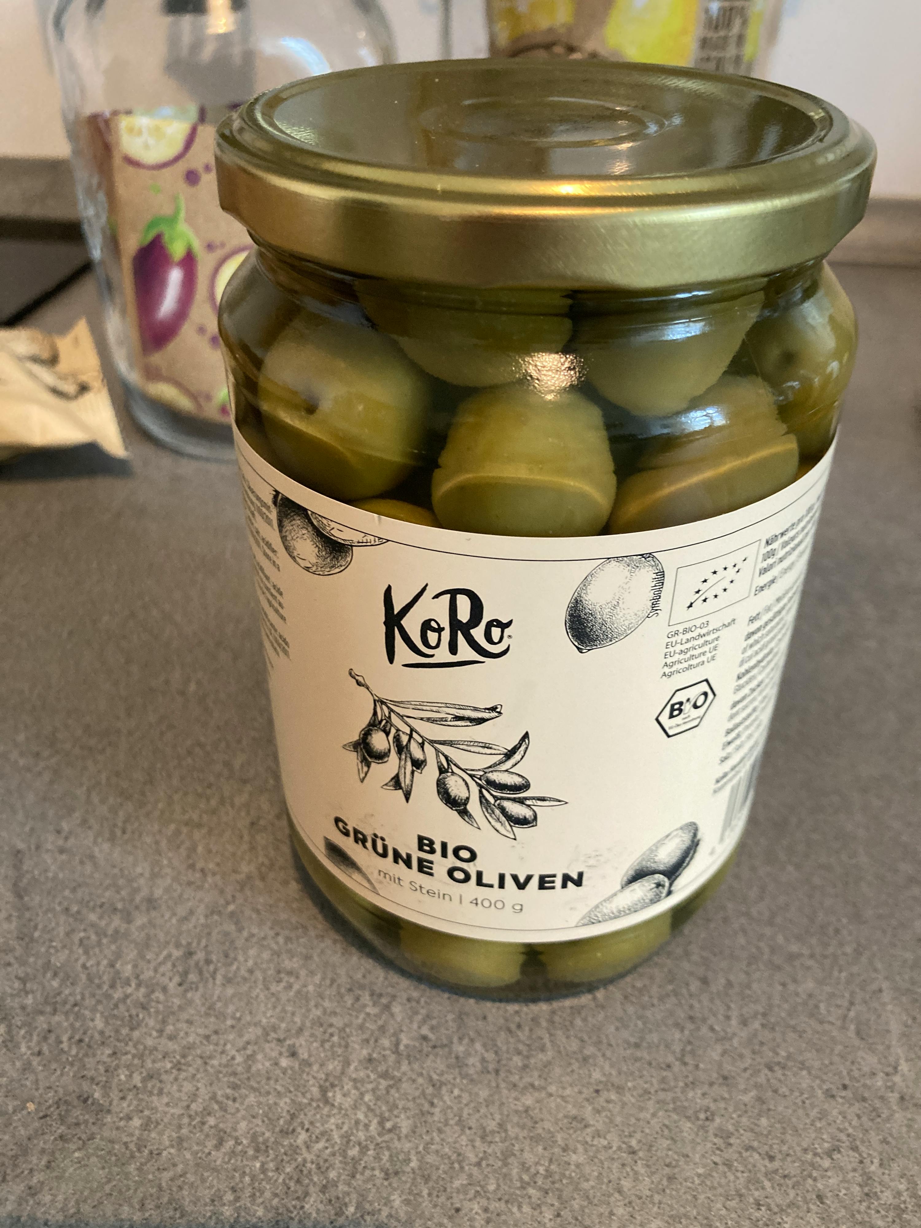a jar of green olives with a label that says " grüne oliven "