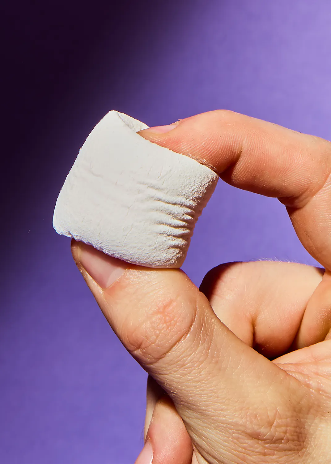 eine Person hält einen weißen Marshmallow in der Hand