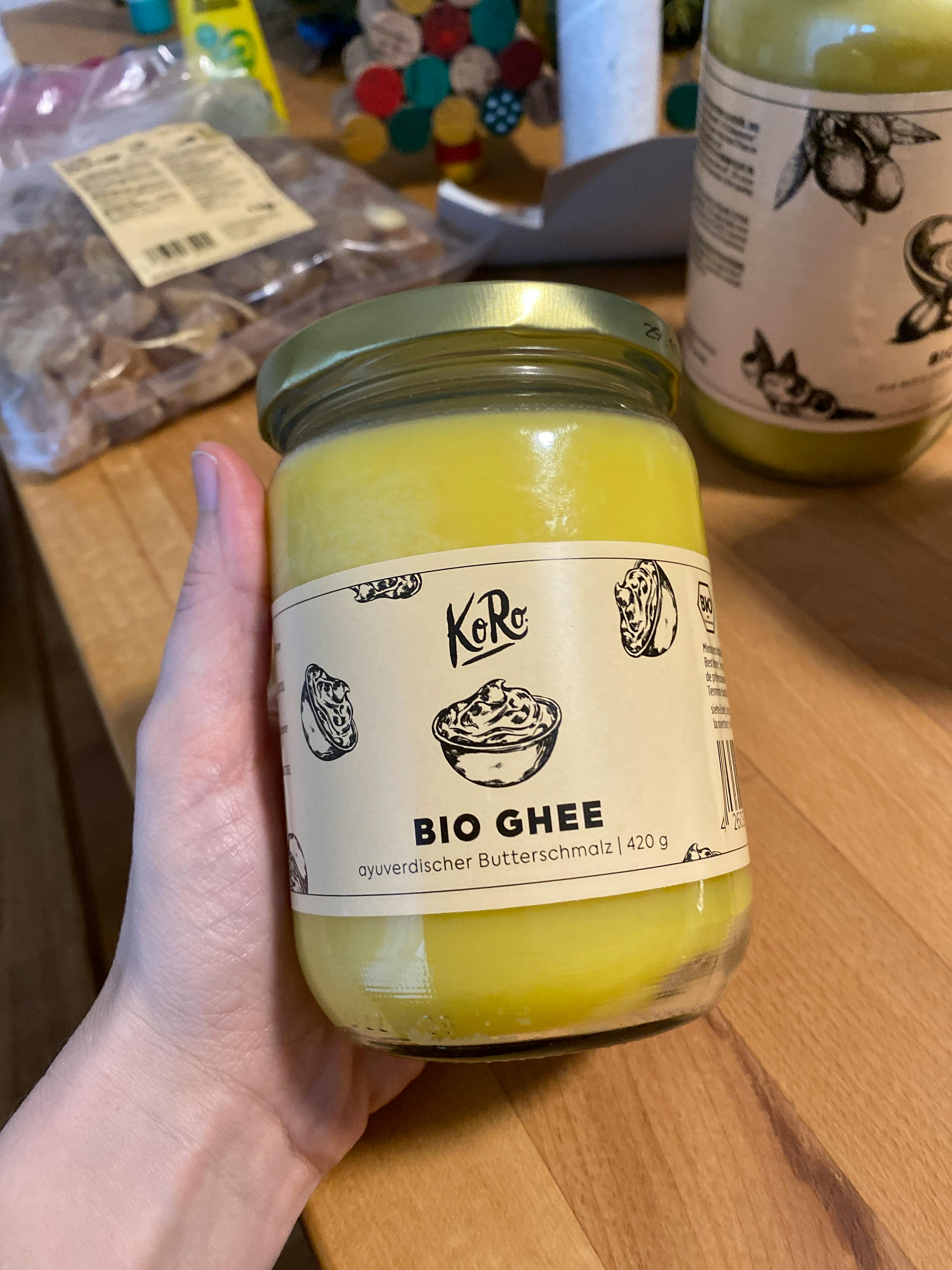 eine Person hält ein Glas bio ghee in der Hand