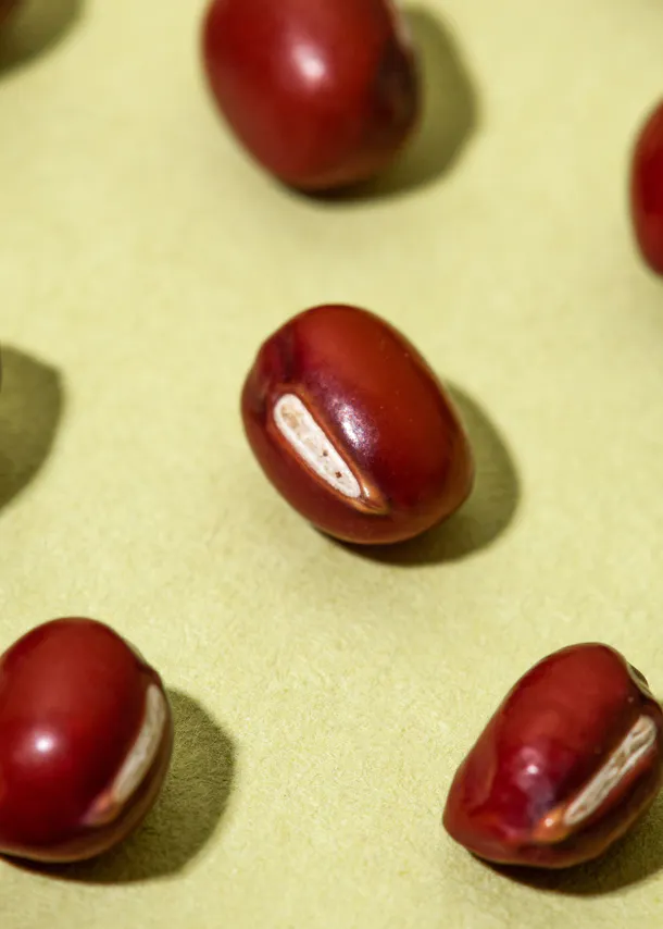a group of red beans on a green surface