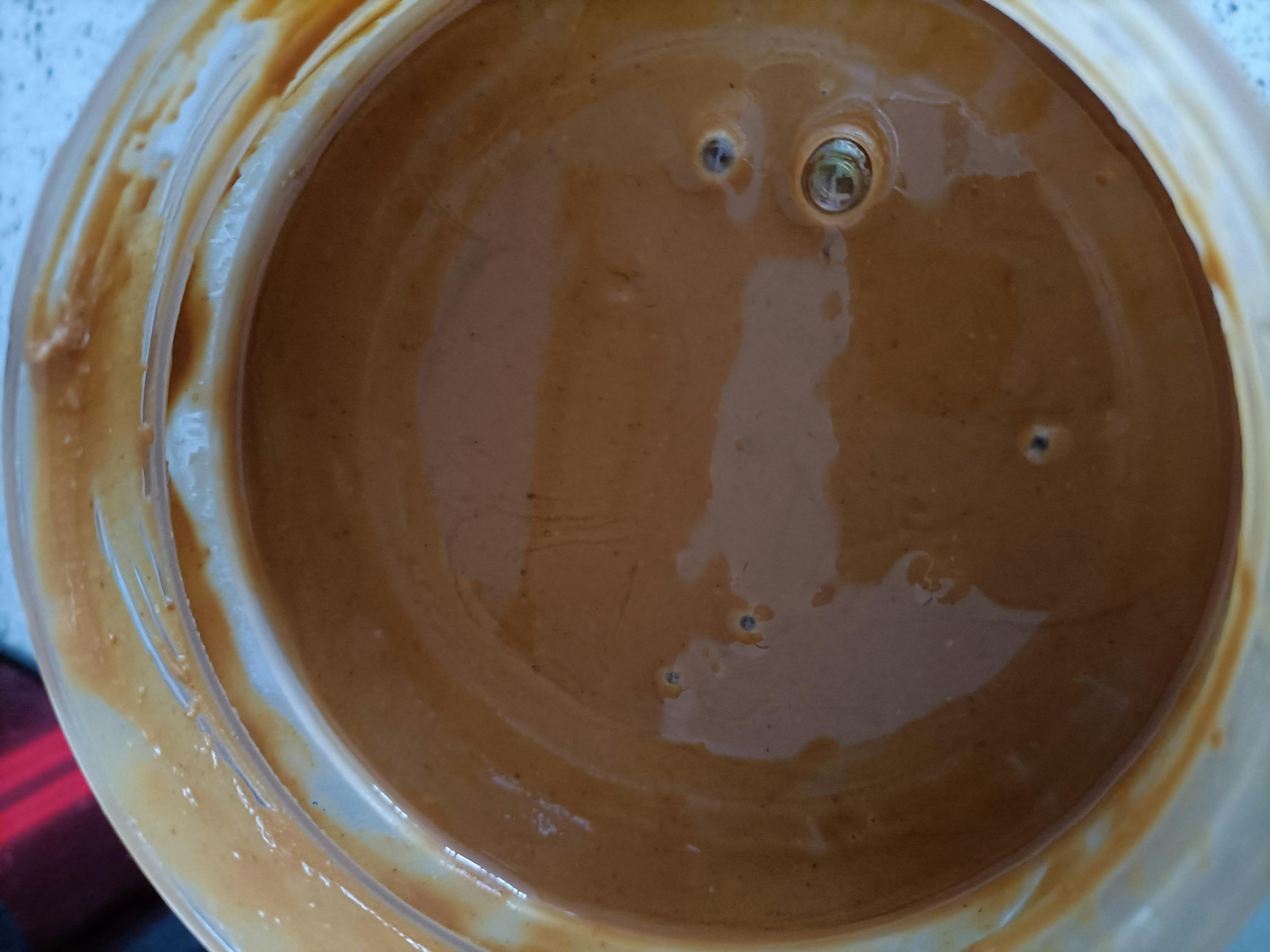 a jar of peanut butter with a hole in the middle