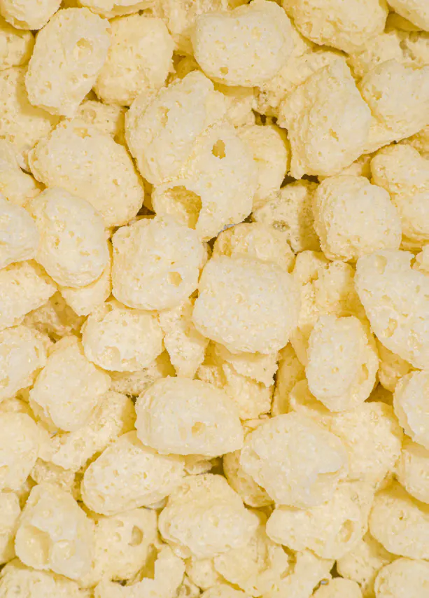 a close-up view of a pile of light yellow, puffed corn cereal pieces.