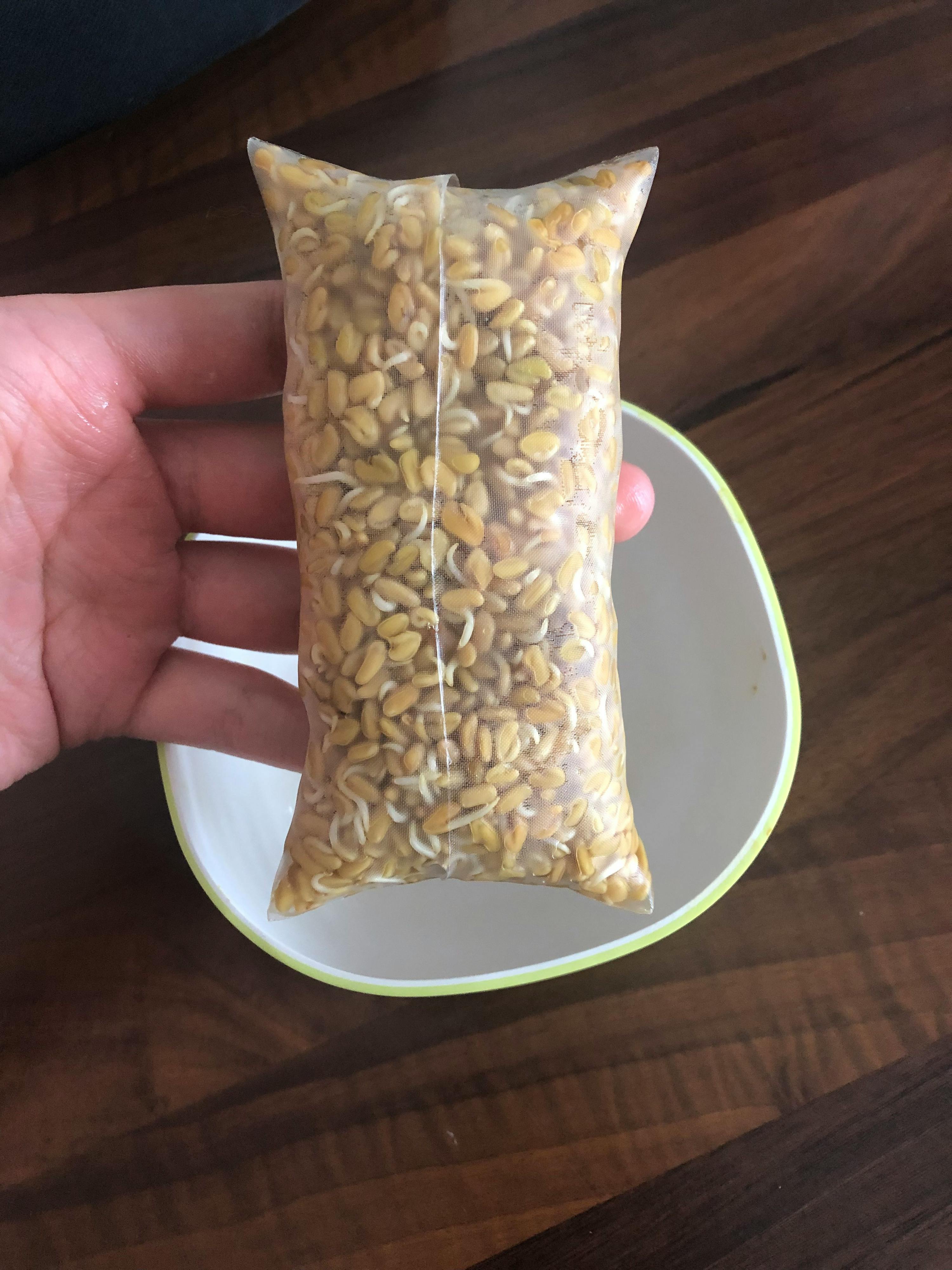 a person is holding a bag of sprouts in their hand