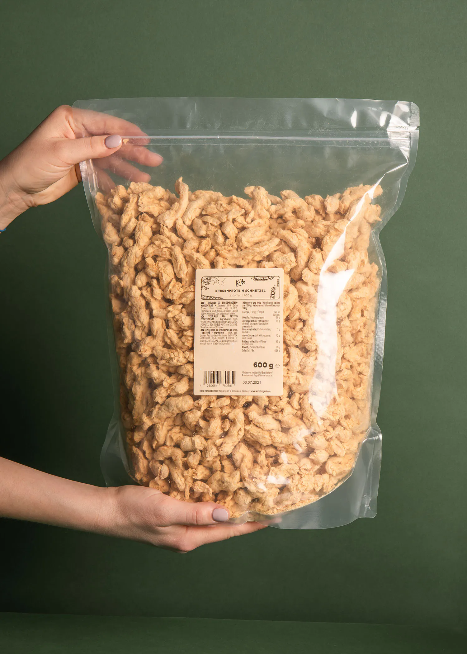 une personne tient un sac de protéines de soja 600 g