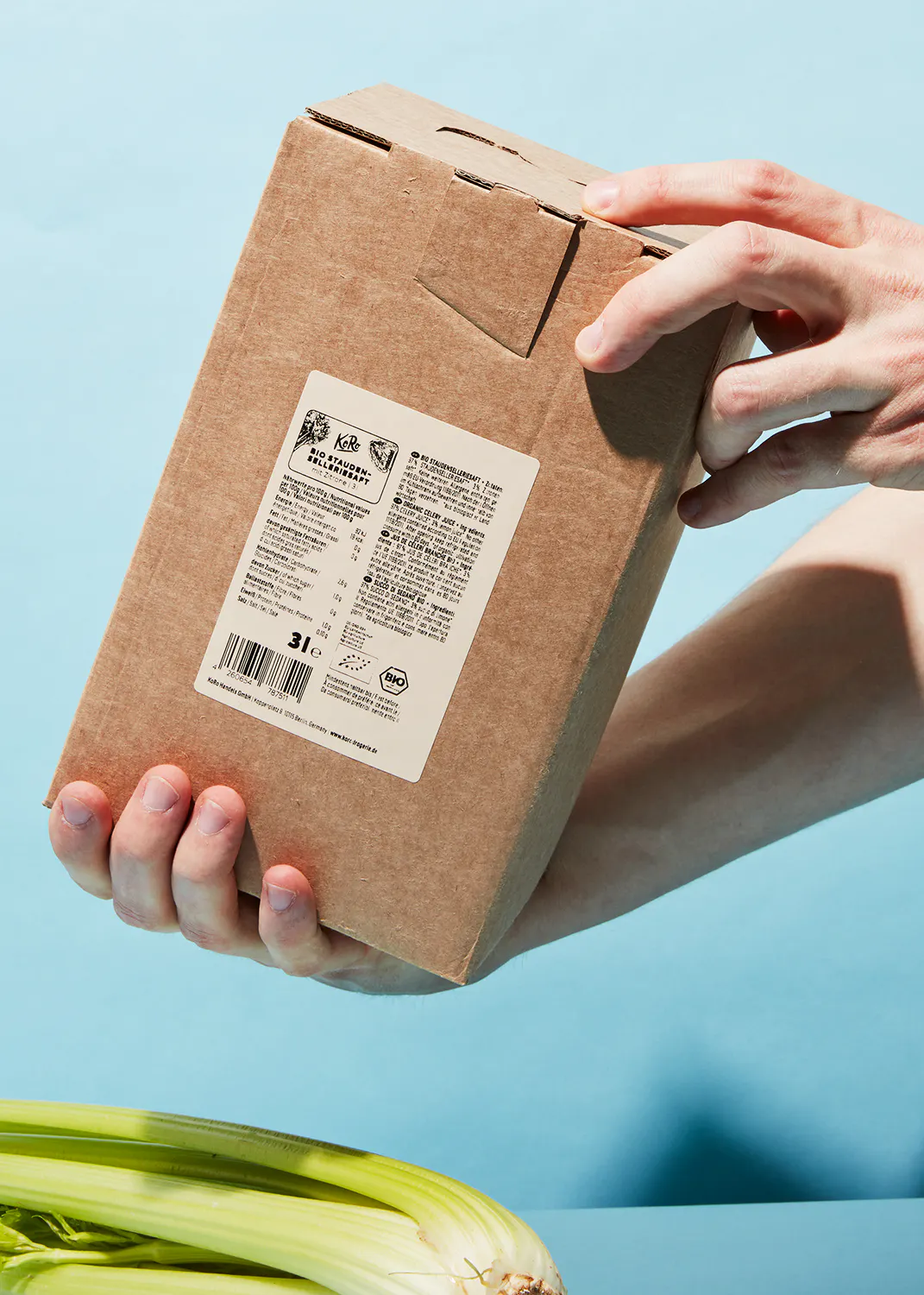 una persona sostiene una caja de cartón con una etiqueta blanca que dice ' bio ' en él