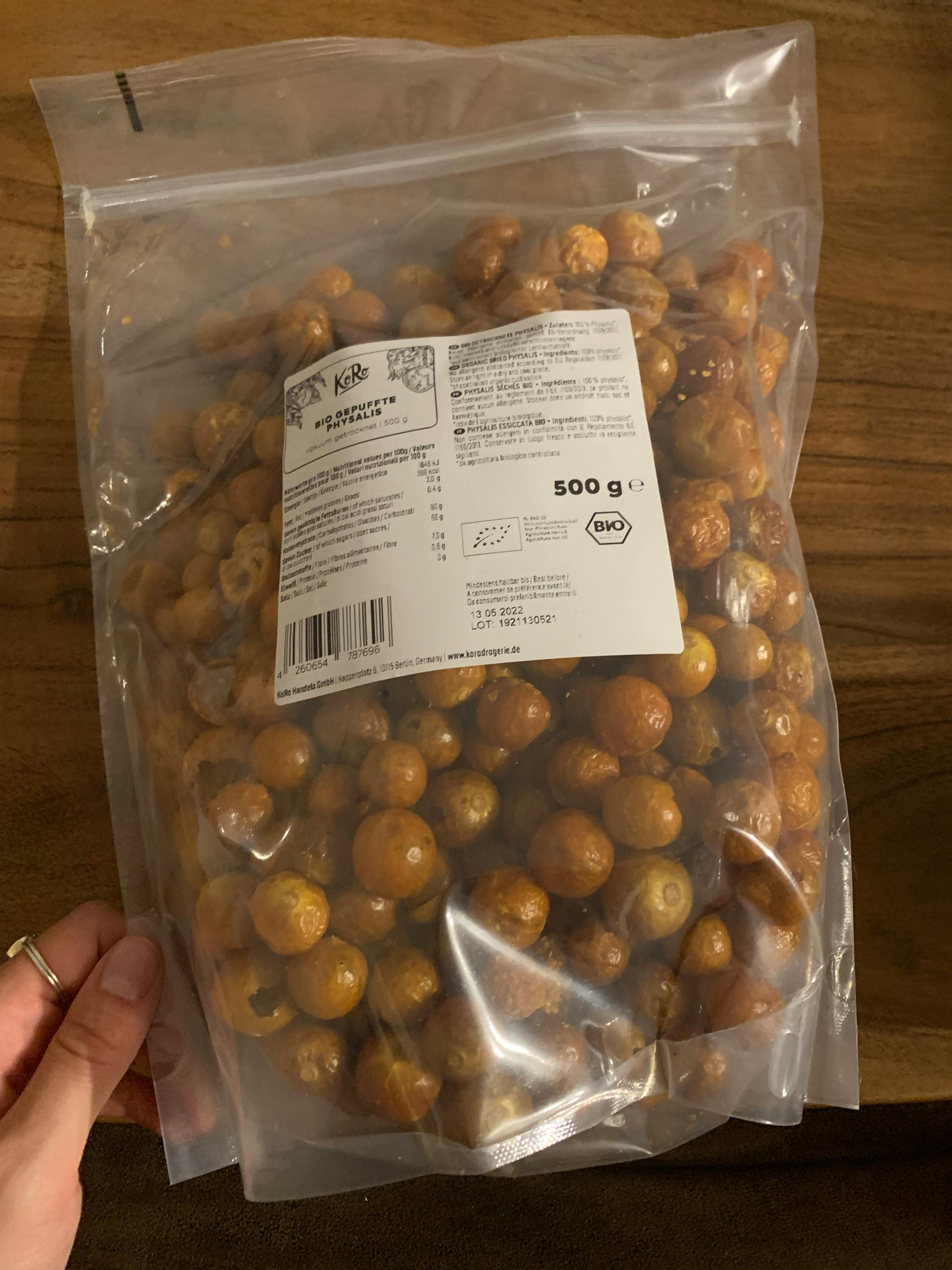 Eine Person hält einen Plastikbeutel mit gerösteten Erdnüssen in ihren Händen