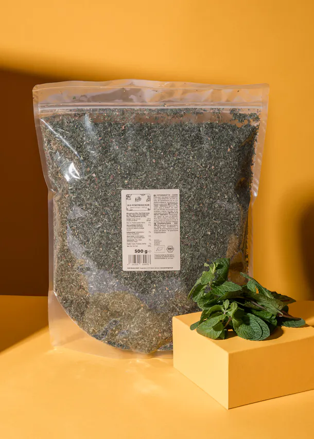 eine Plastiktüte mit Kräutern steht neben einem Stück Minz