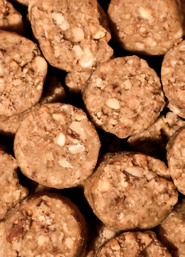 primer plano de varias galletas redondas de color marrón claro con trozos de nueces visibles.