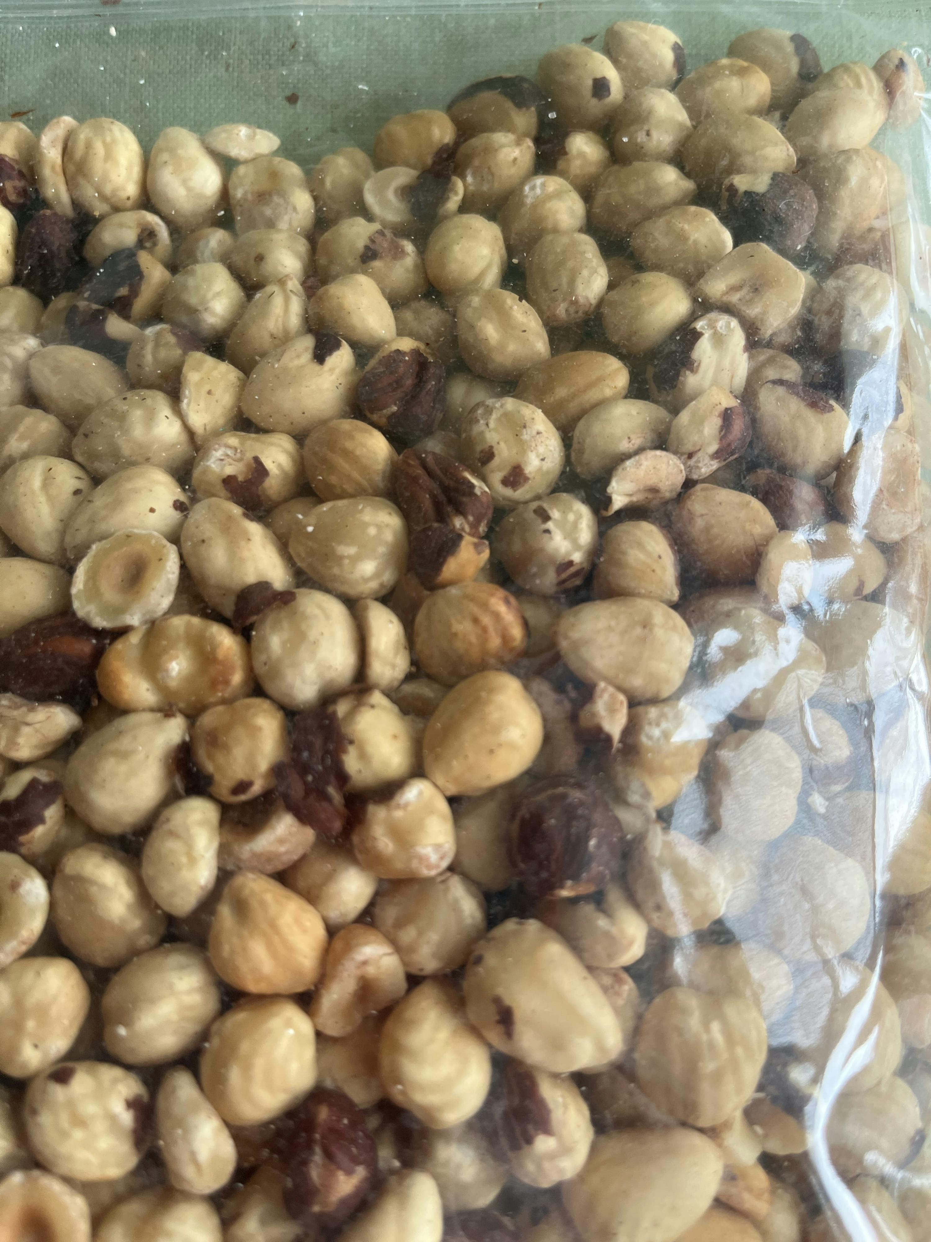 ein nahaufnahmebild von vielen geschälten haselnüssen in einer durchsichtigen verpackung.