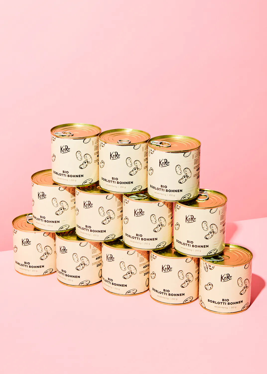 a stack of cans of bio sogliotti sohnen on a pink background