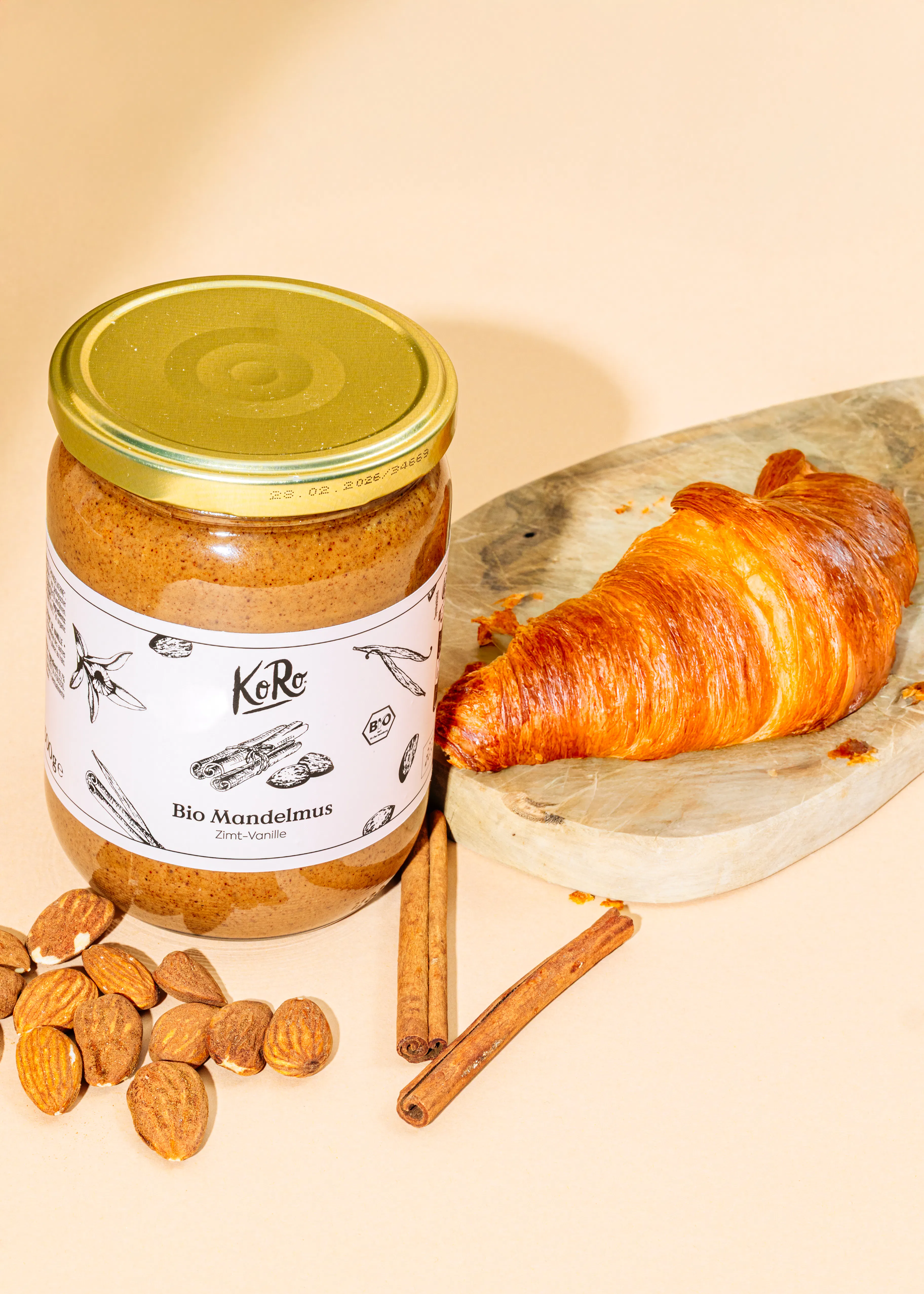 ein Glas Bio Mandelmus steht neben einem Croissant