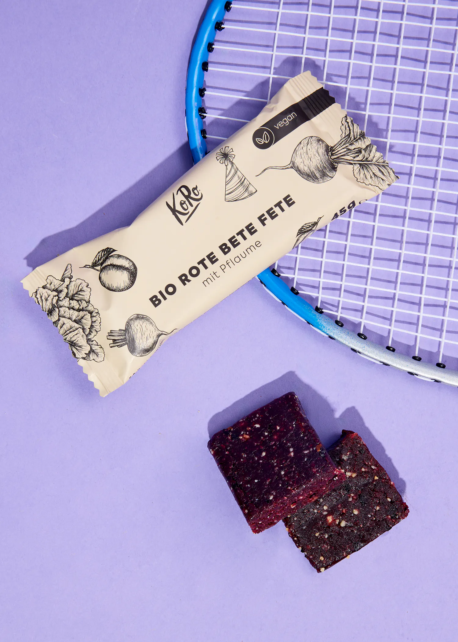 une barre bio rote bete fete est assise à côté d' une raquette de tennis