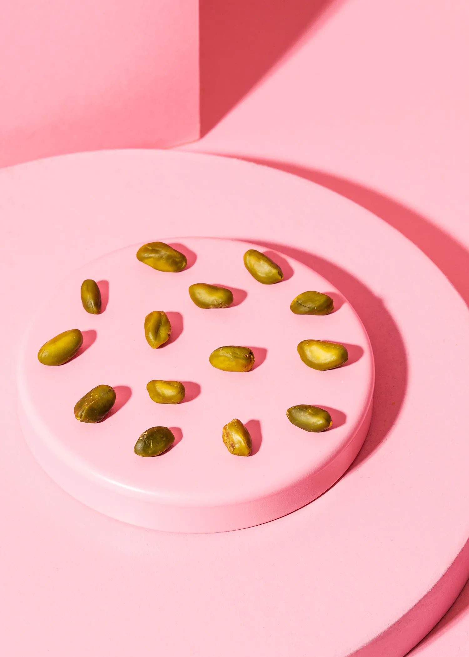 les pistaches sont disposées en cercle sur un plateau rose