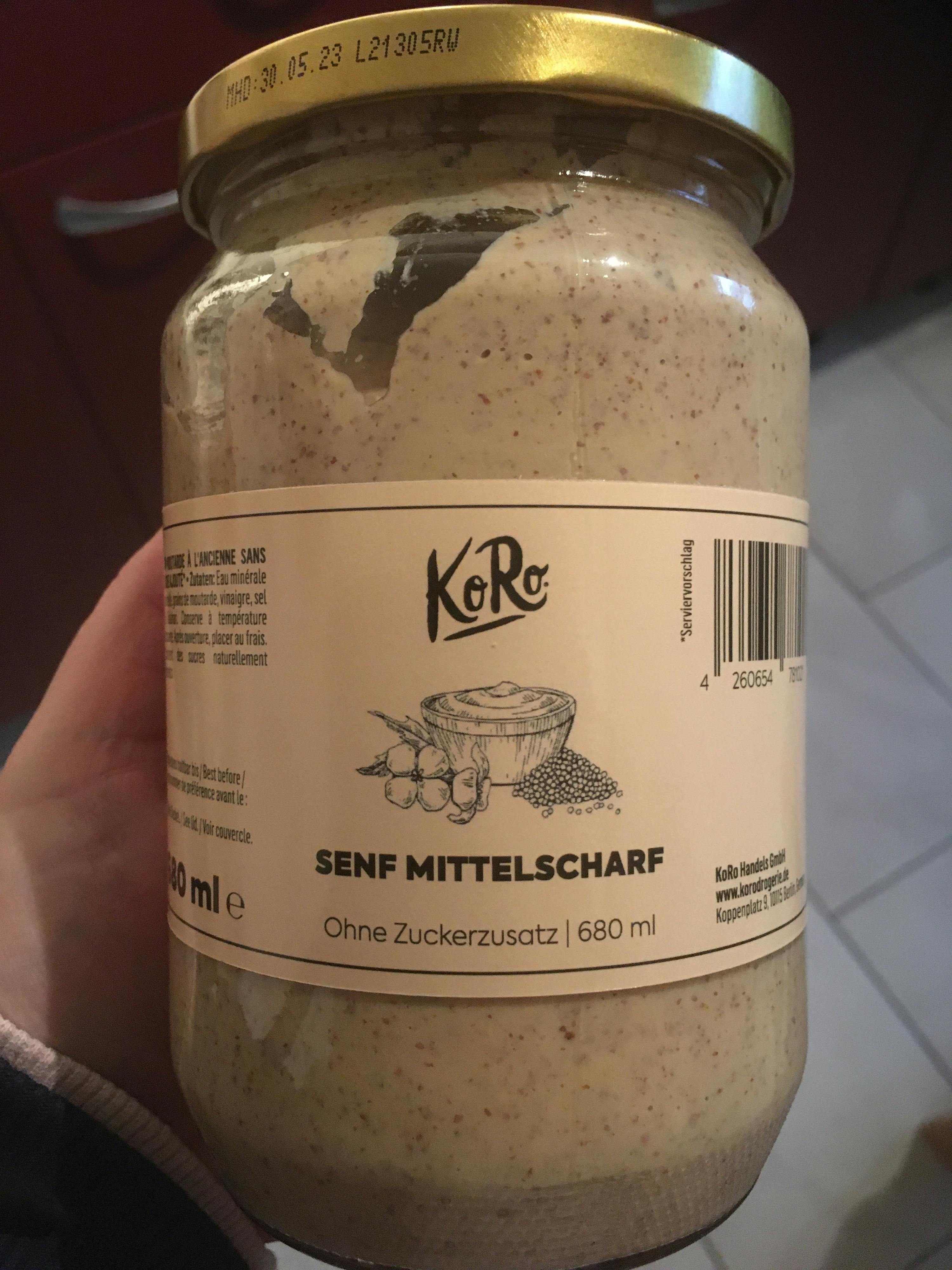 una persona tiene in mano un barattolo di senf mittelscharf