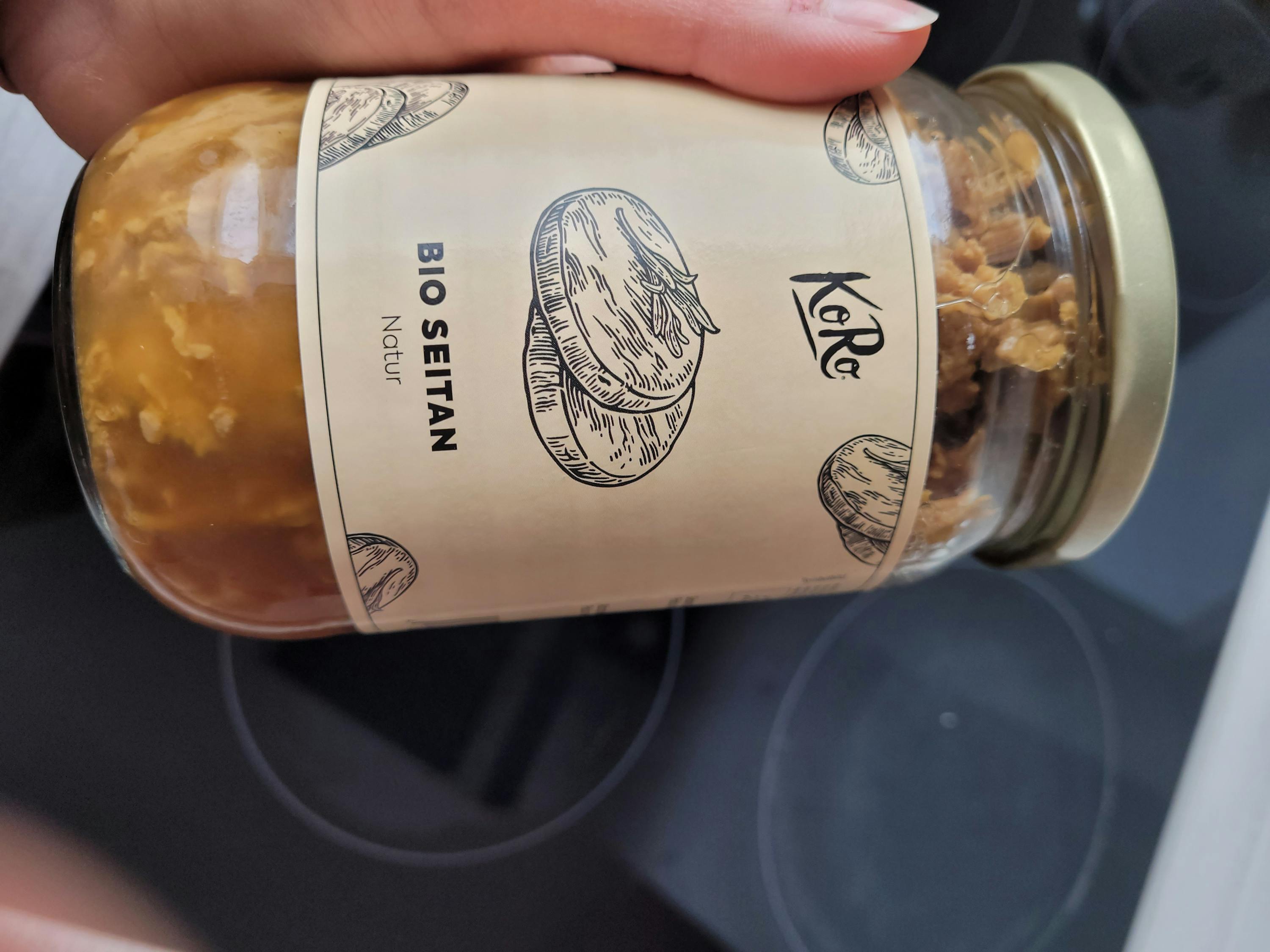 una persona tiene in mano un barattolo di seitan bio