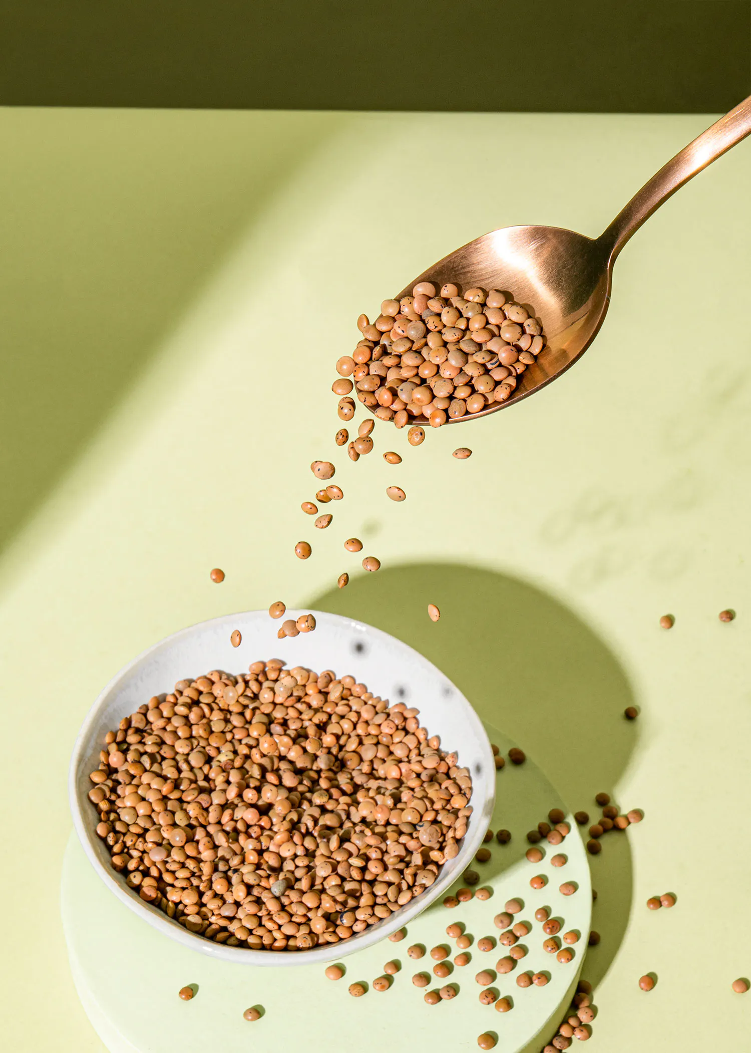 a bowl of lentils is being poured into a spoon