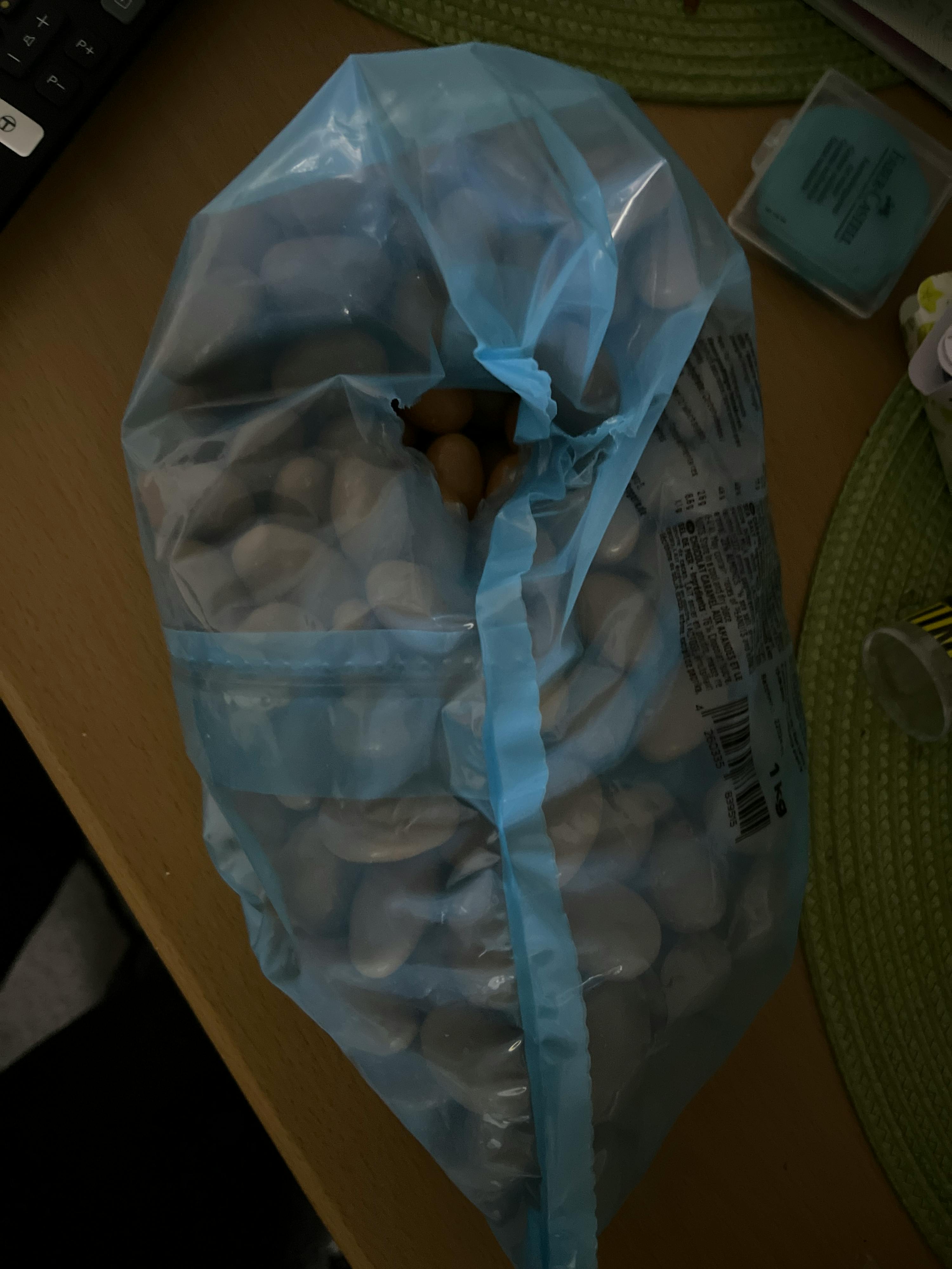 un sac en plastique bleu rempli de pierres blanches