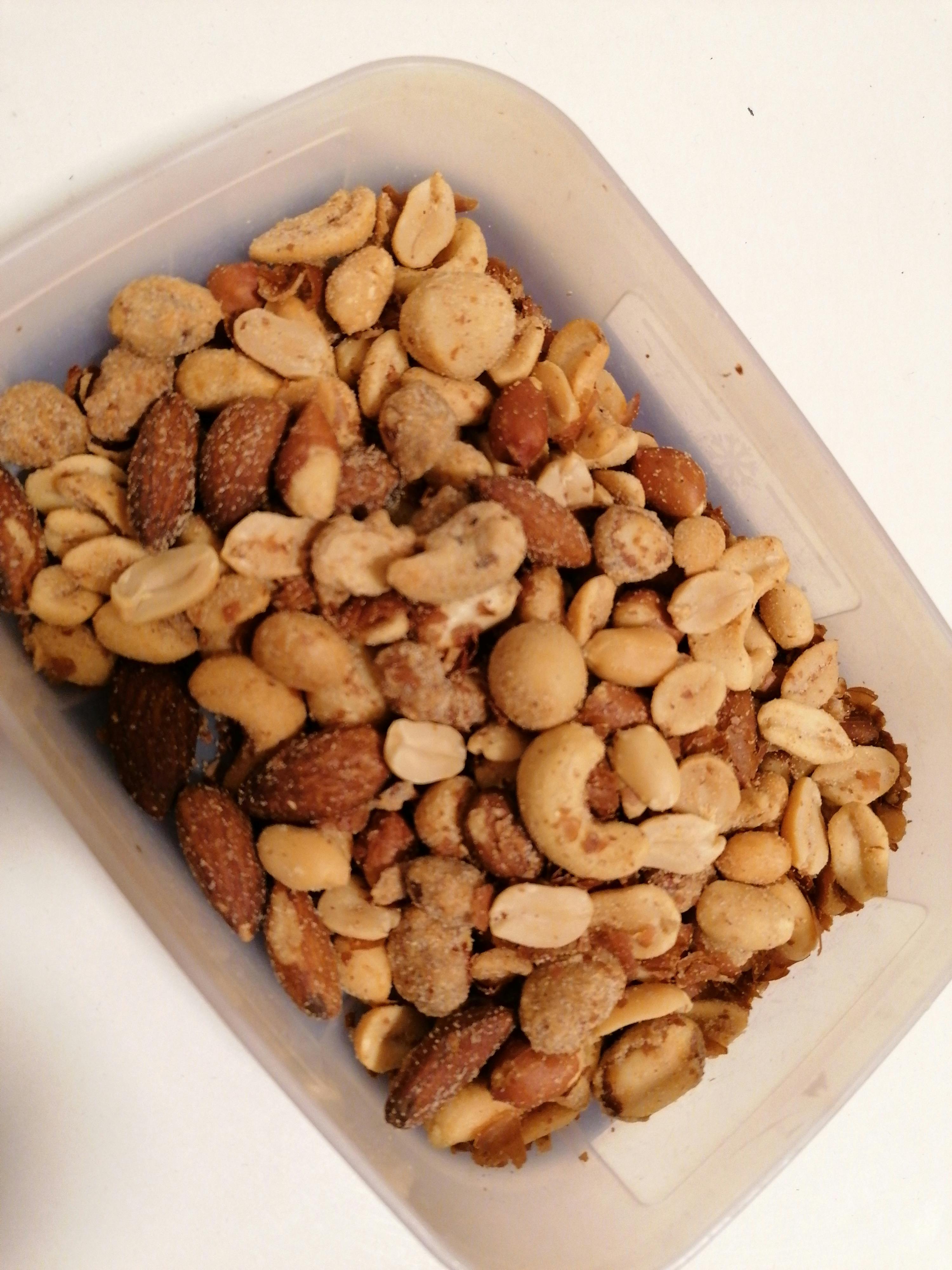 un contenitore di plastica pieno di noci e arachidi