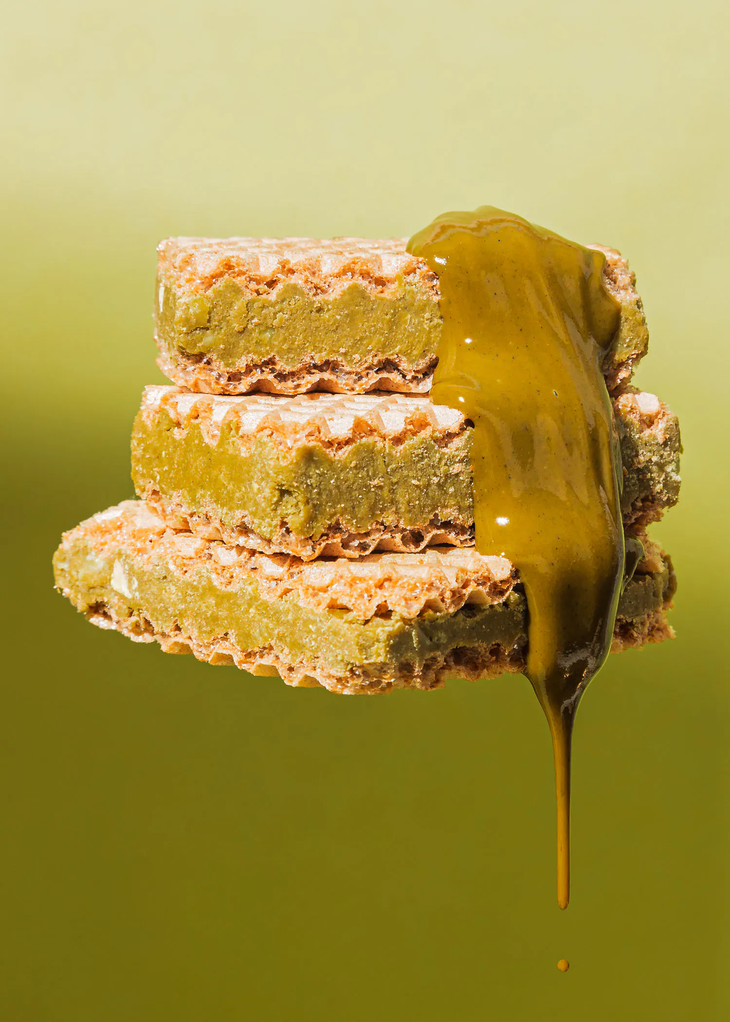 trois biscuits empilés les uns sur les autres avec une sauce verte coulant dessus