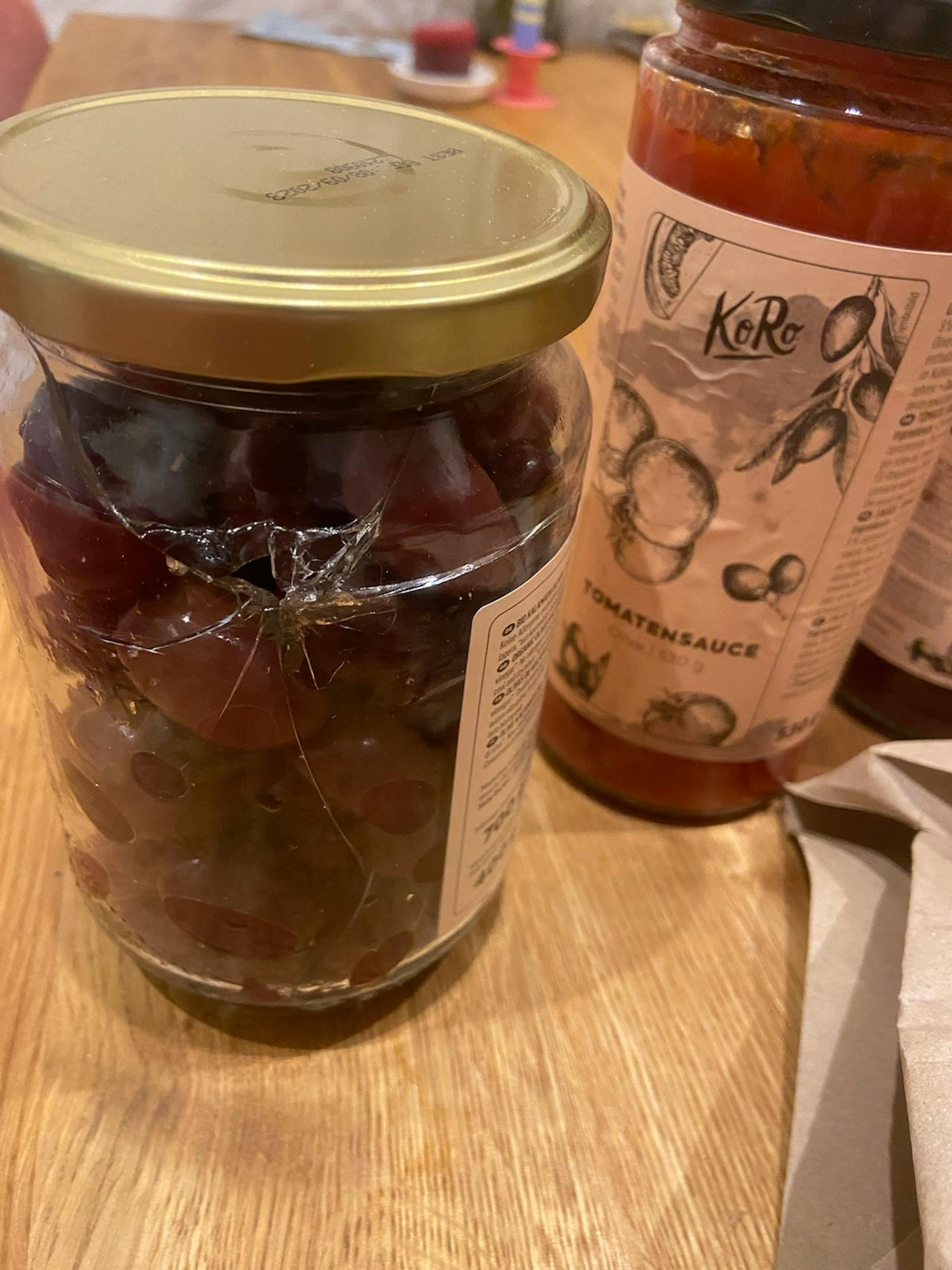 ein mit Tomatensauce gefülltes Glas auf einem Holztisch