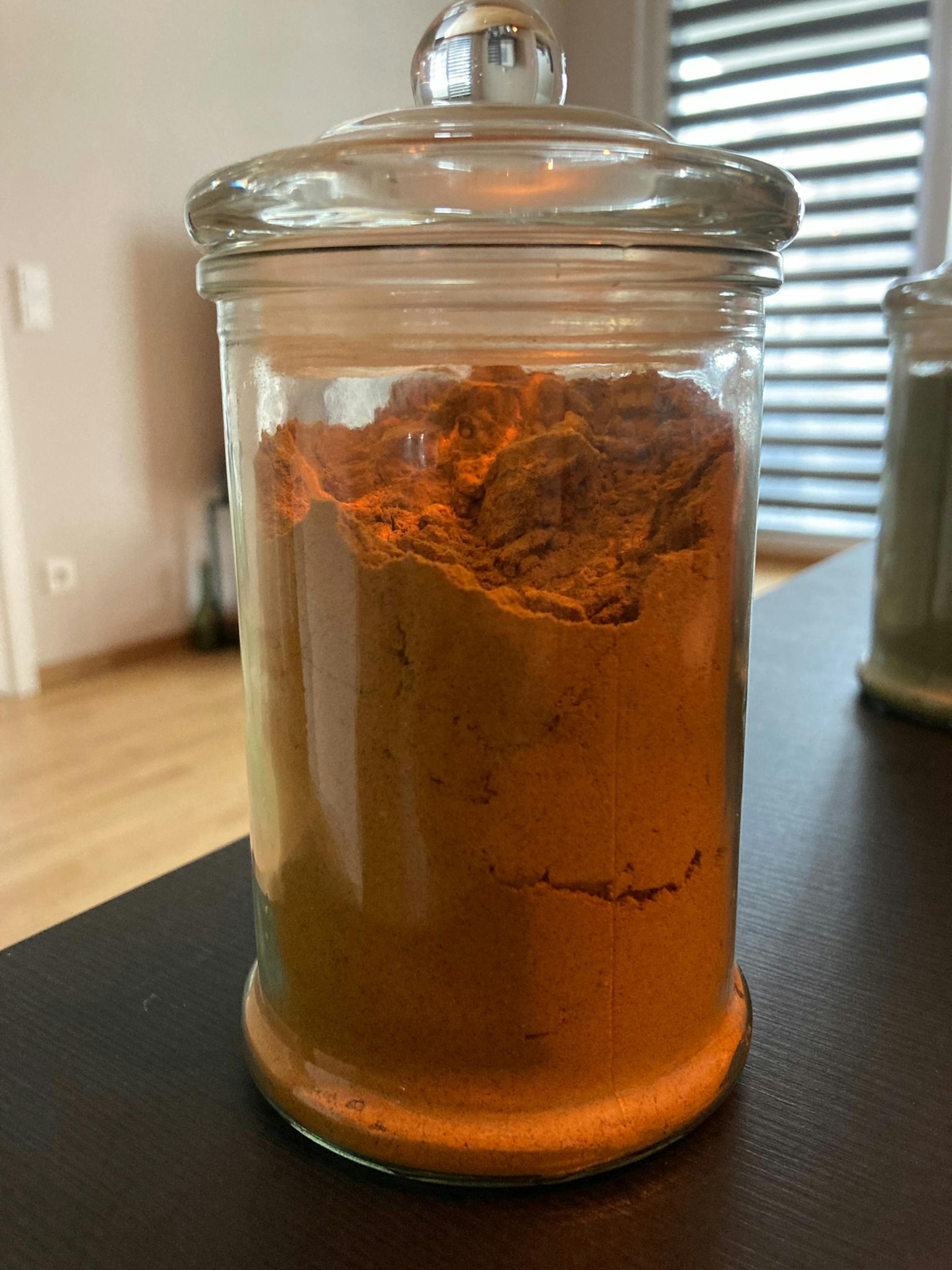 ein Glas mit einem Deckel voller Gewürze auf einem Tisch