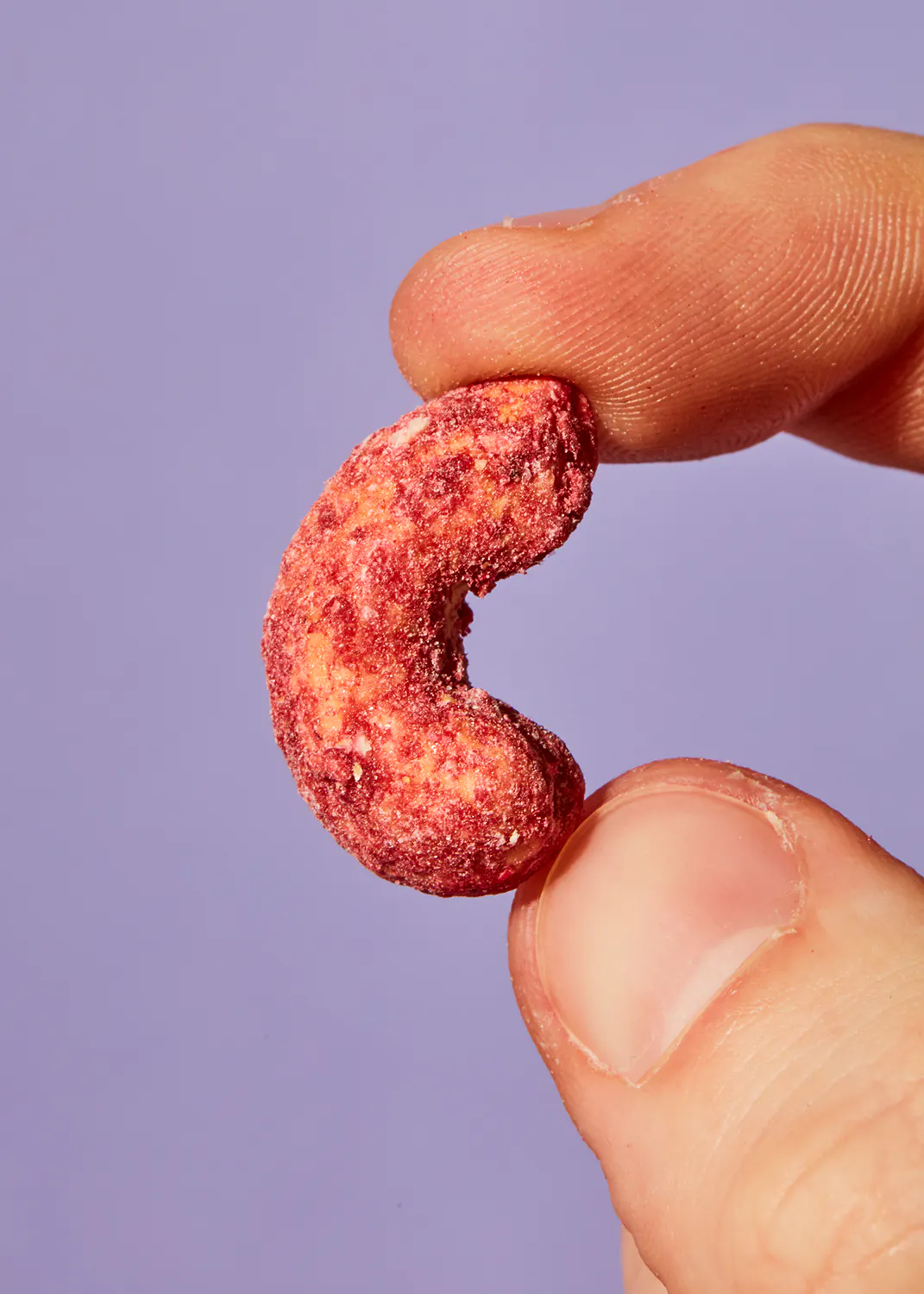 a person is holding a red candy in their hand