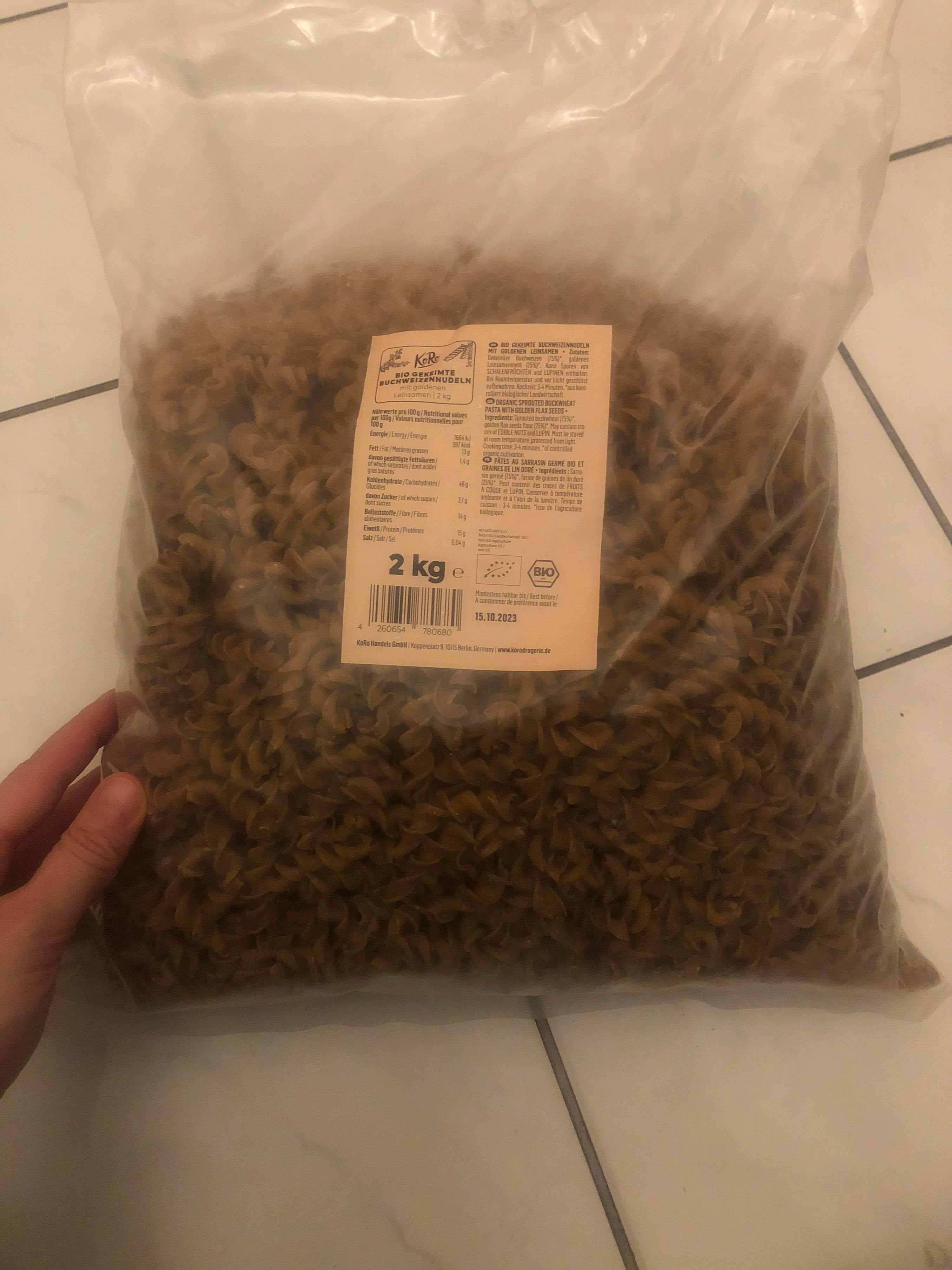 a person is holding a bag of pasta that says 2 kg