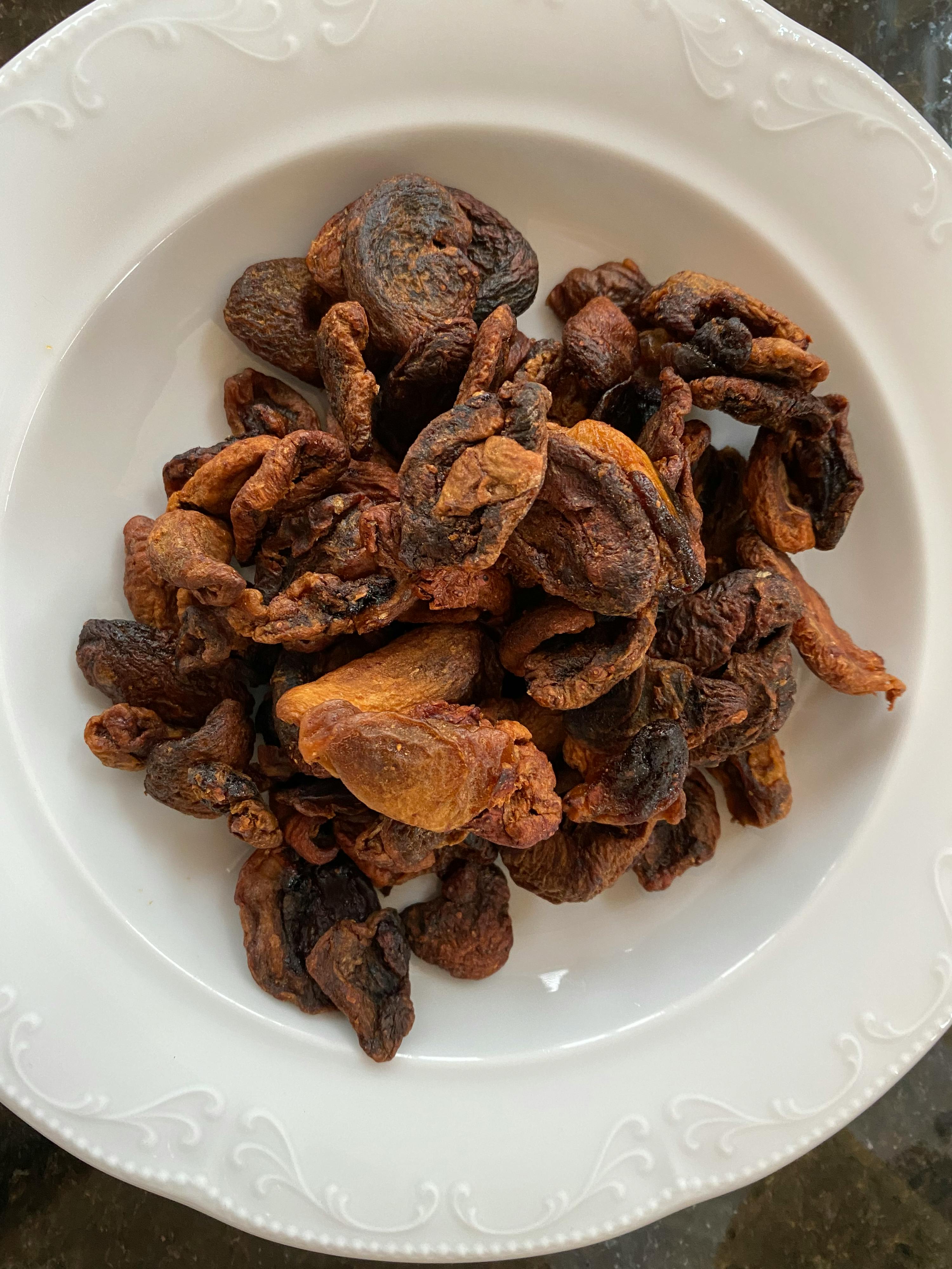 un bol blanc rempli de fruits secs bruns