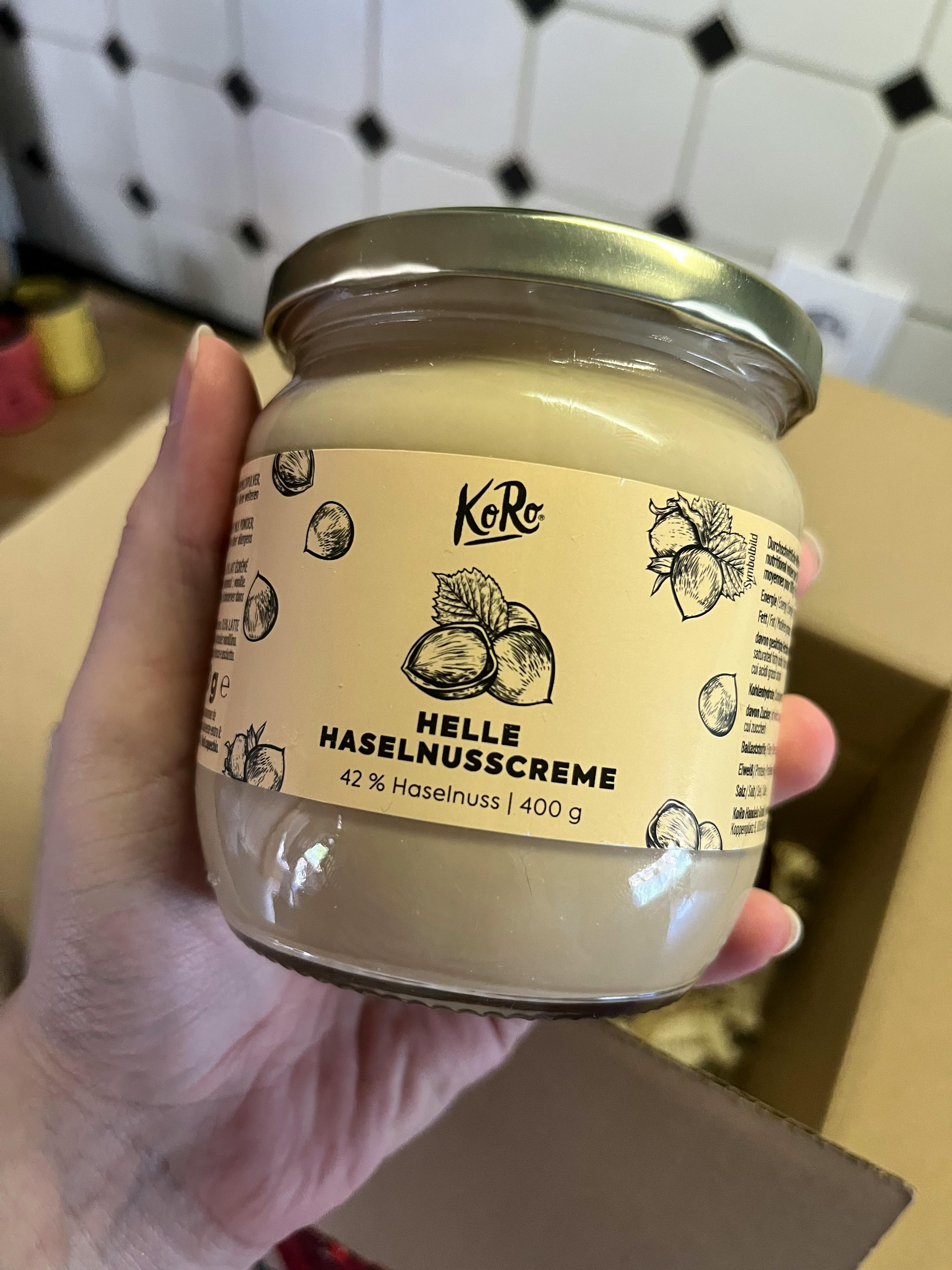 a person is holding a jar of helle hazelnusscreme