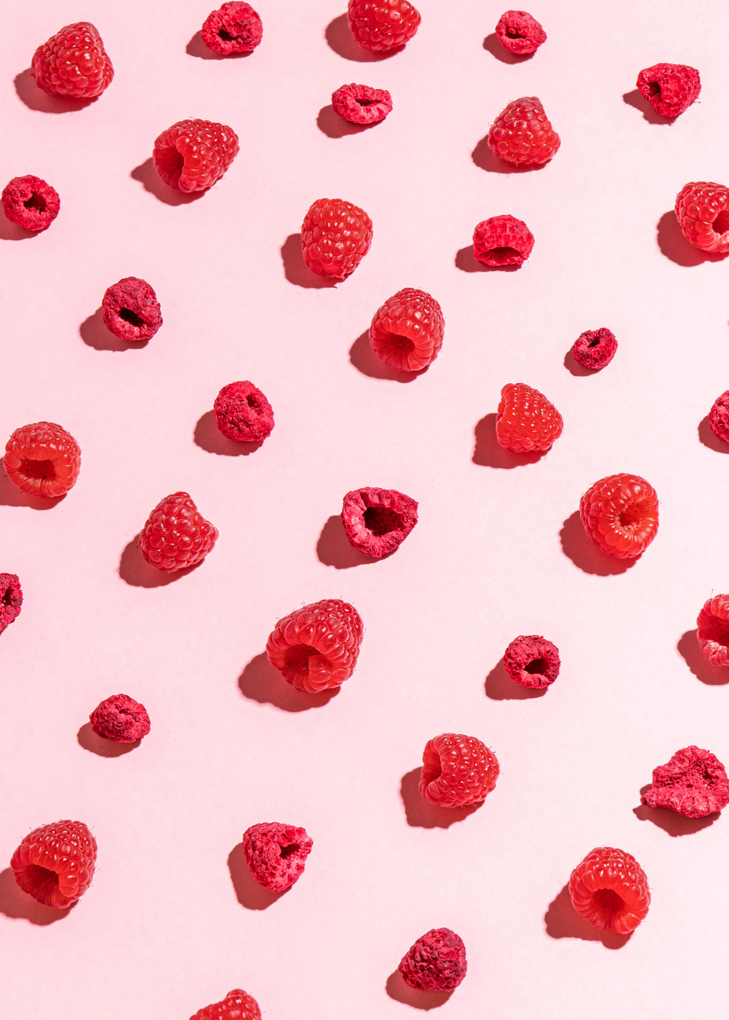 raspberries are arranged in a pattern on a pink background