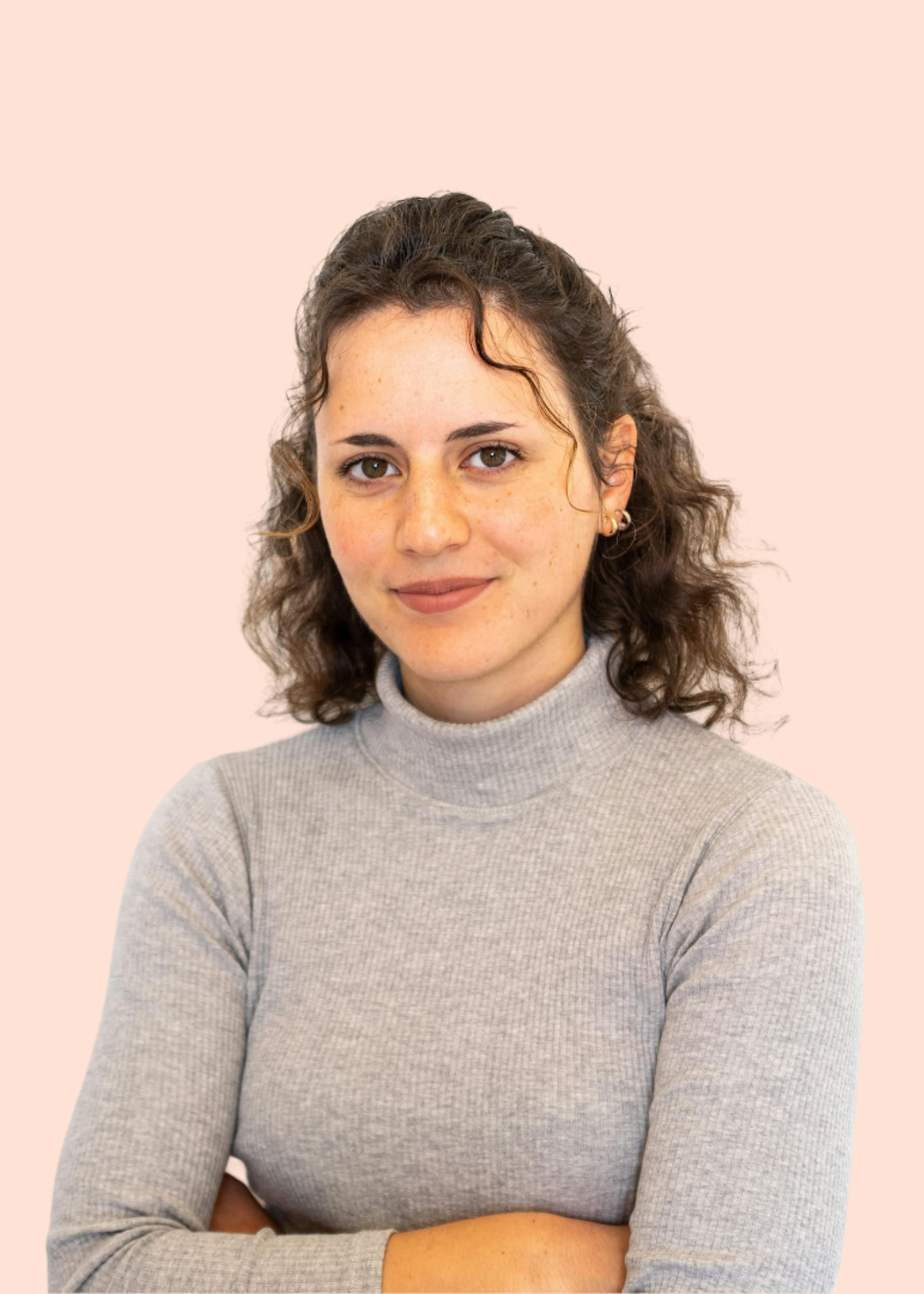 Eine Frau trägt einen grauen Pullover mit ihren Armen verschränkt