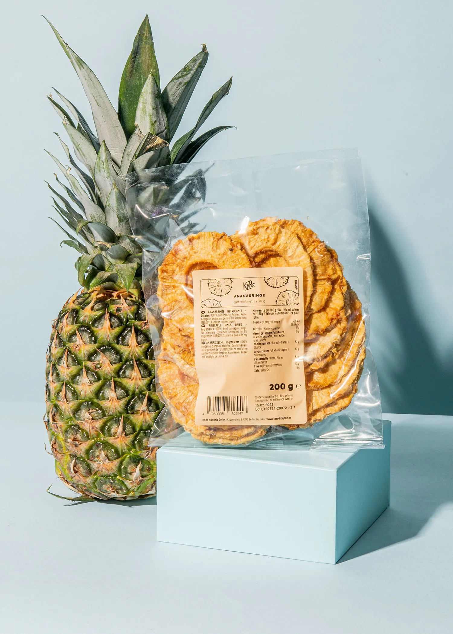 a pineapple next to a bag of pineapple slices